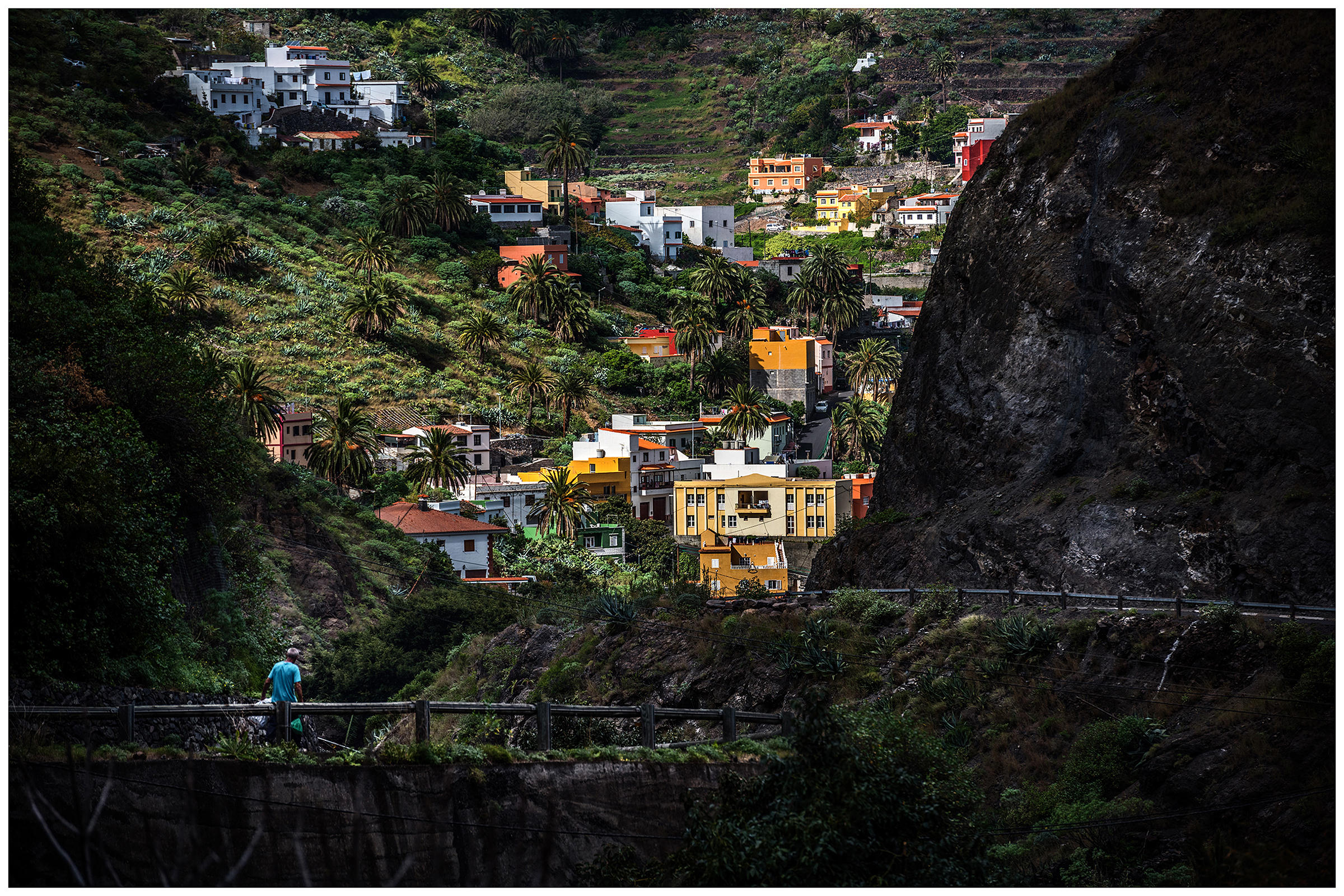 La Gomera, Canary Islands, Spain. A man carries two plastic cakes near Hermigua.