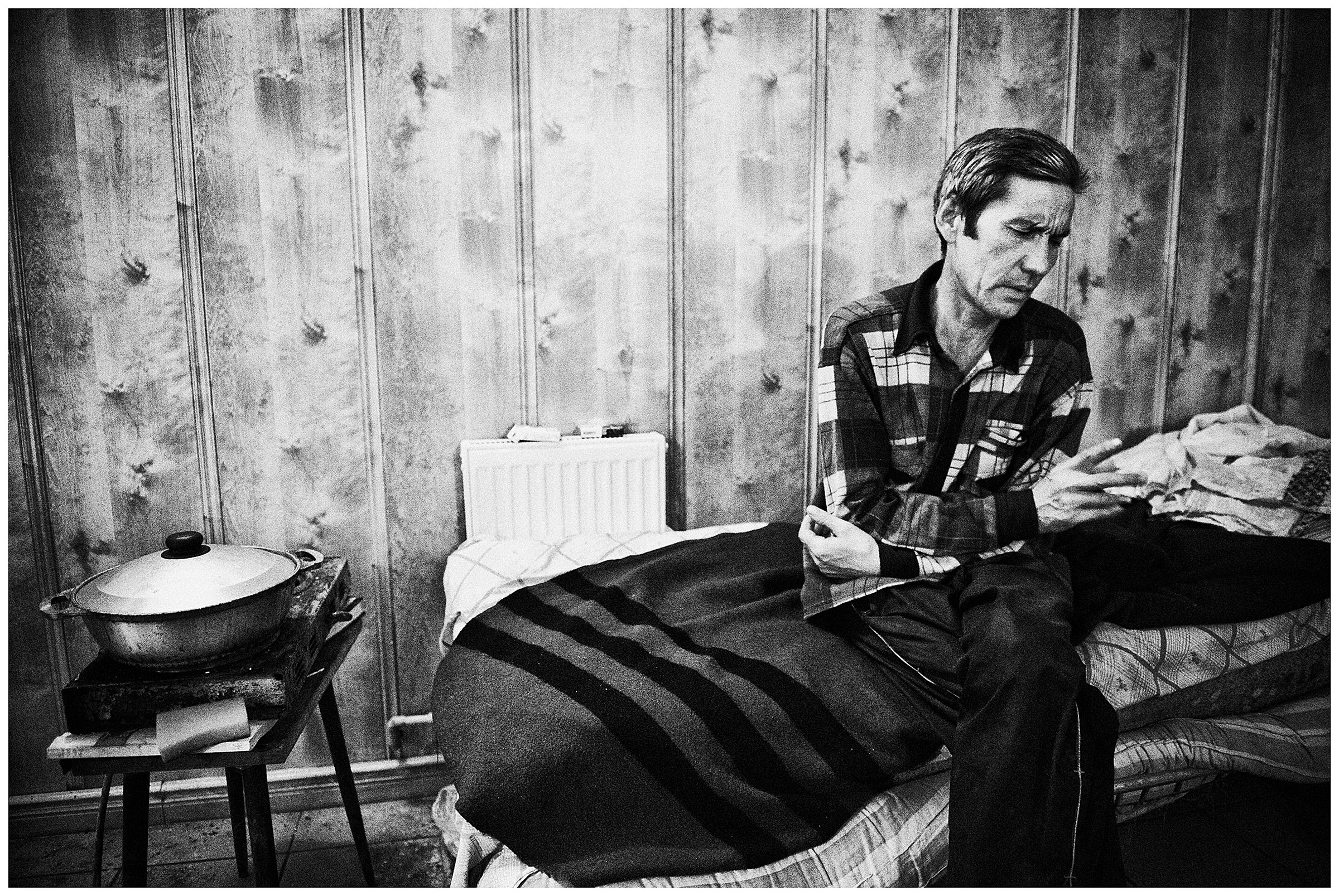 Kaliningrad, Russia. A man, an Uzbek guest worker, is sitting on a bed.