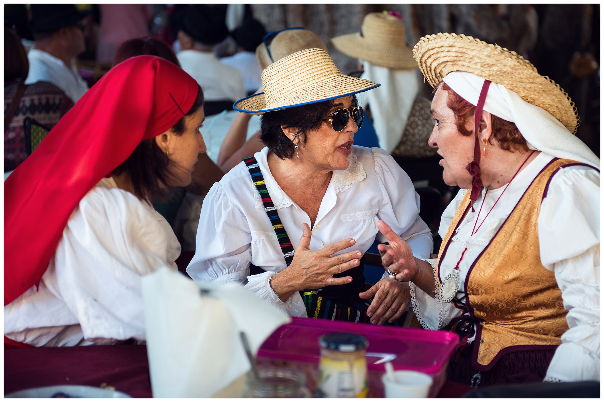 San Sebastian de la Gomera, La Gomera, Canary Islands, Spain. The inhabitants of the city of San Sebastian de la Gomera celebrate the city festival Romeria. Three women converse at a table.