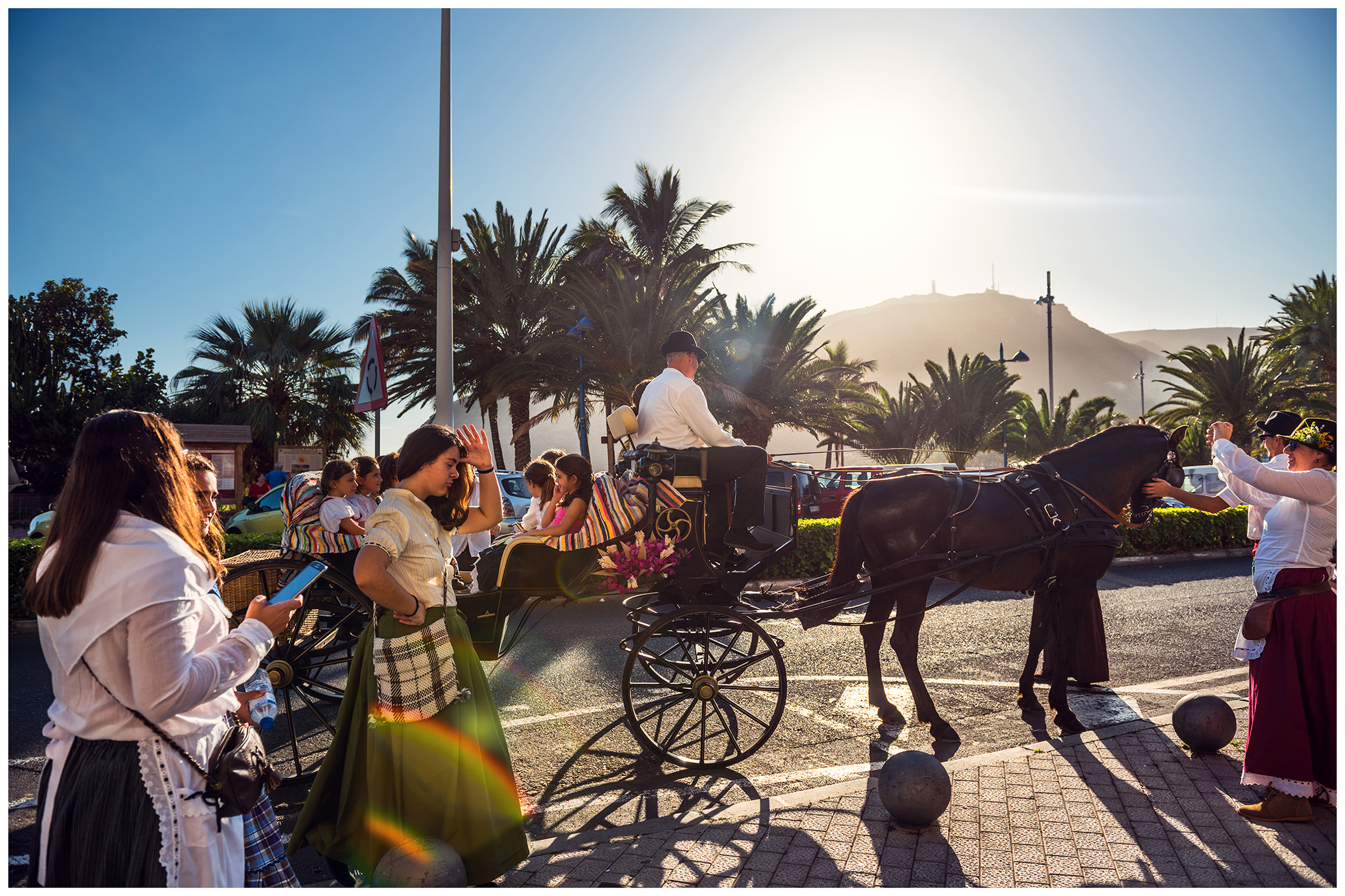 San Sebastian de la Gomera, La Gomera, Canary Islands, Spain. The inhabitants of the city San Sebastian de la Gomera celebrate the city festival Romeria. A carriage with children stands near the city promenade.