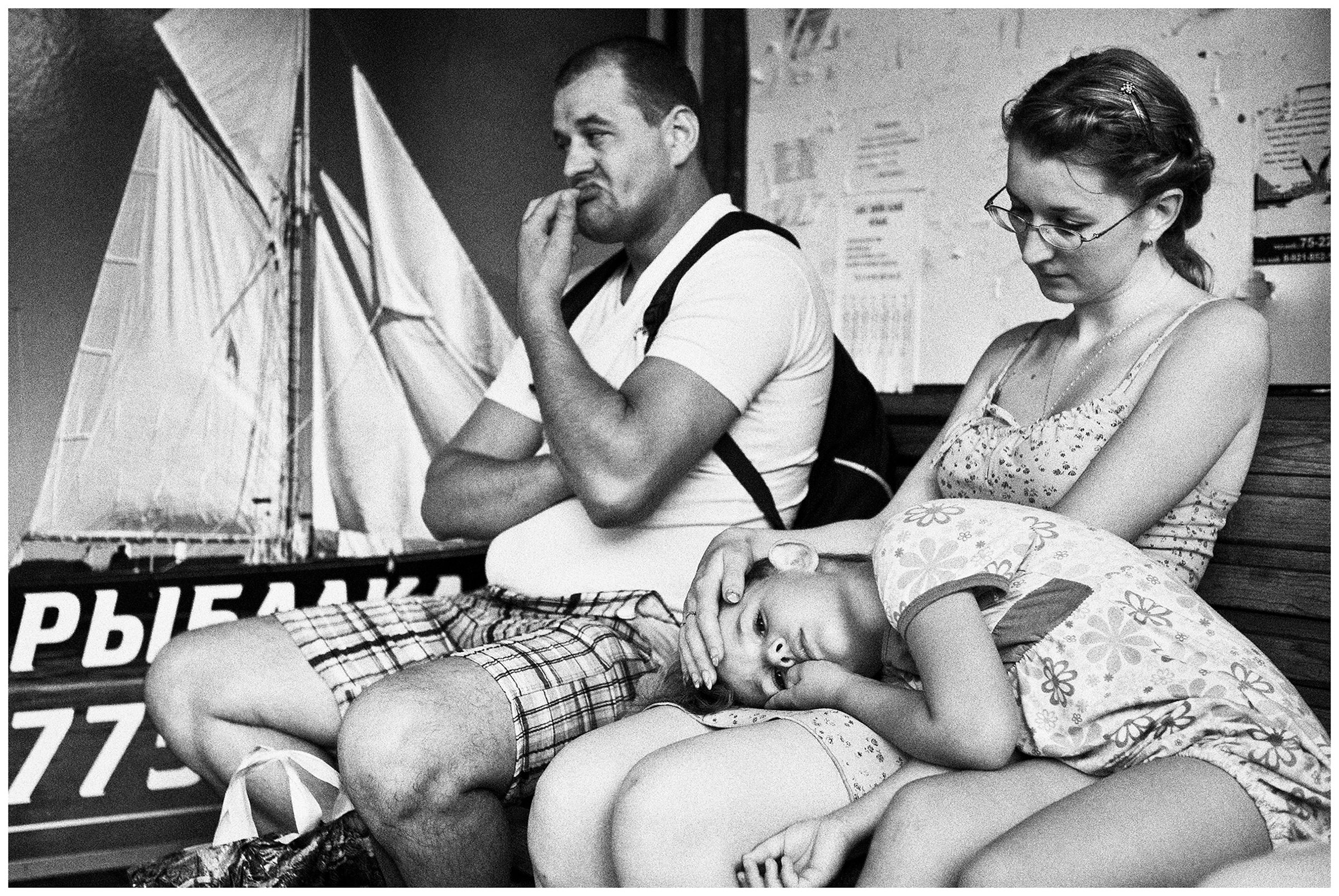 Kaliningrad, Russia. A man, a woman and a girl are waiting for a bus at a bus stop.