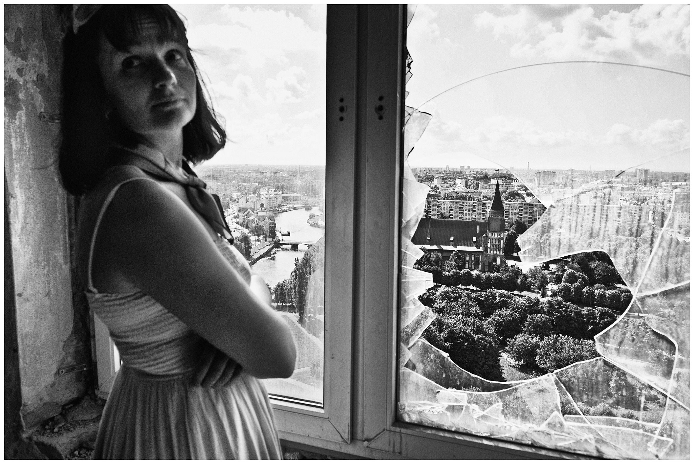 Kaliningrad, Russia. A woman in Dom Sovetov stands in front of a broken window pane.