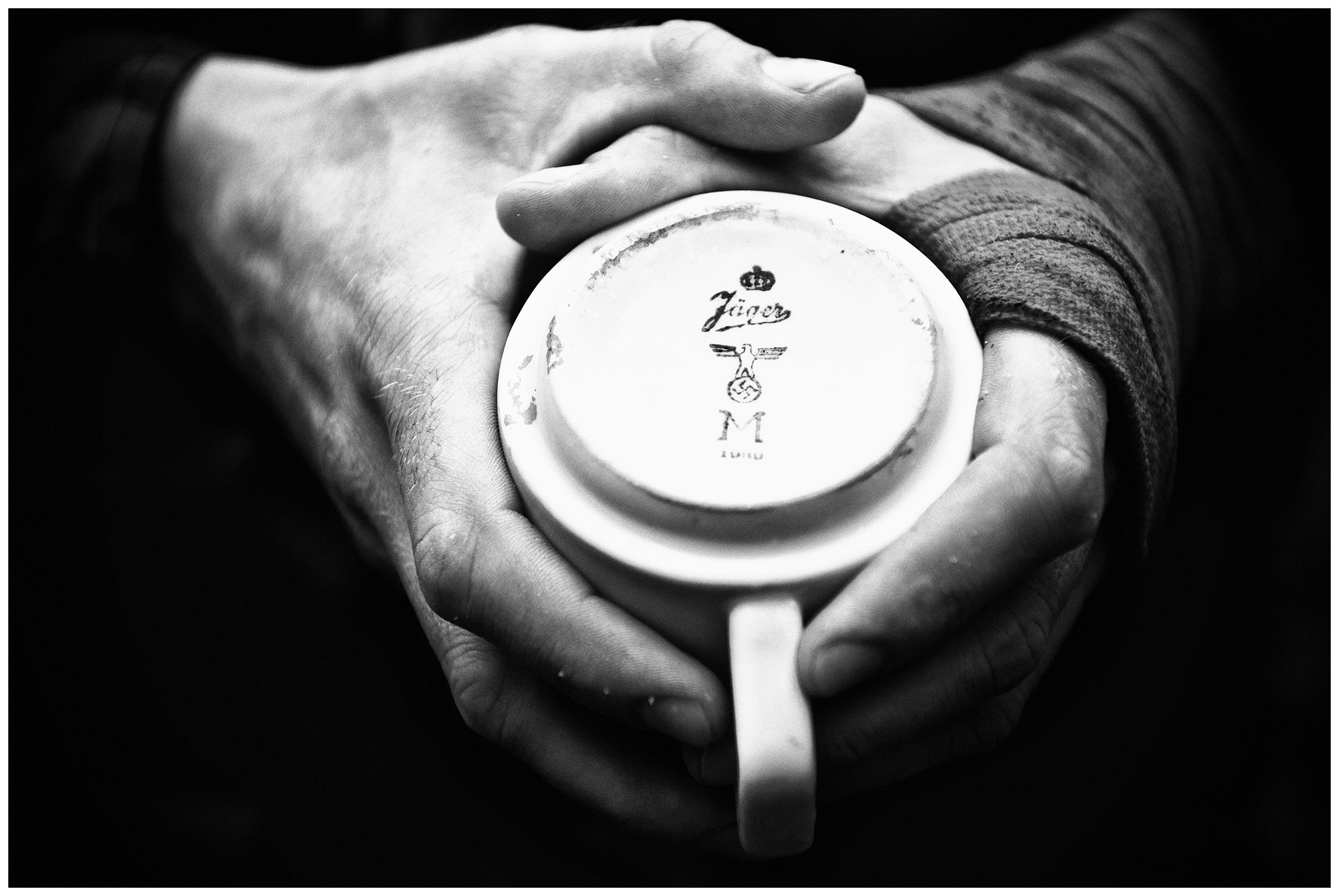 Kaliningrad, Russia. A man holds a cup with a swastika, which he found on the site of Balga Fortress.