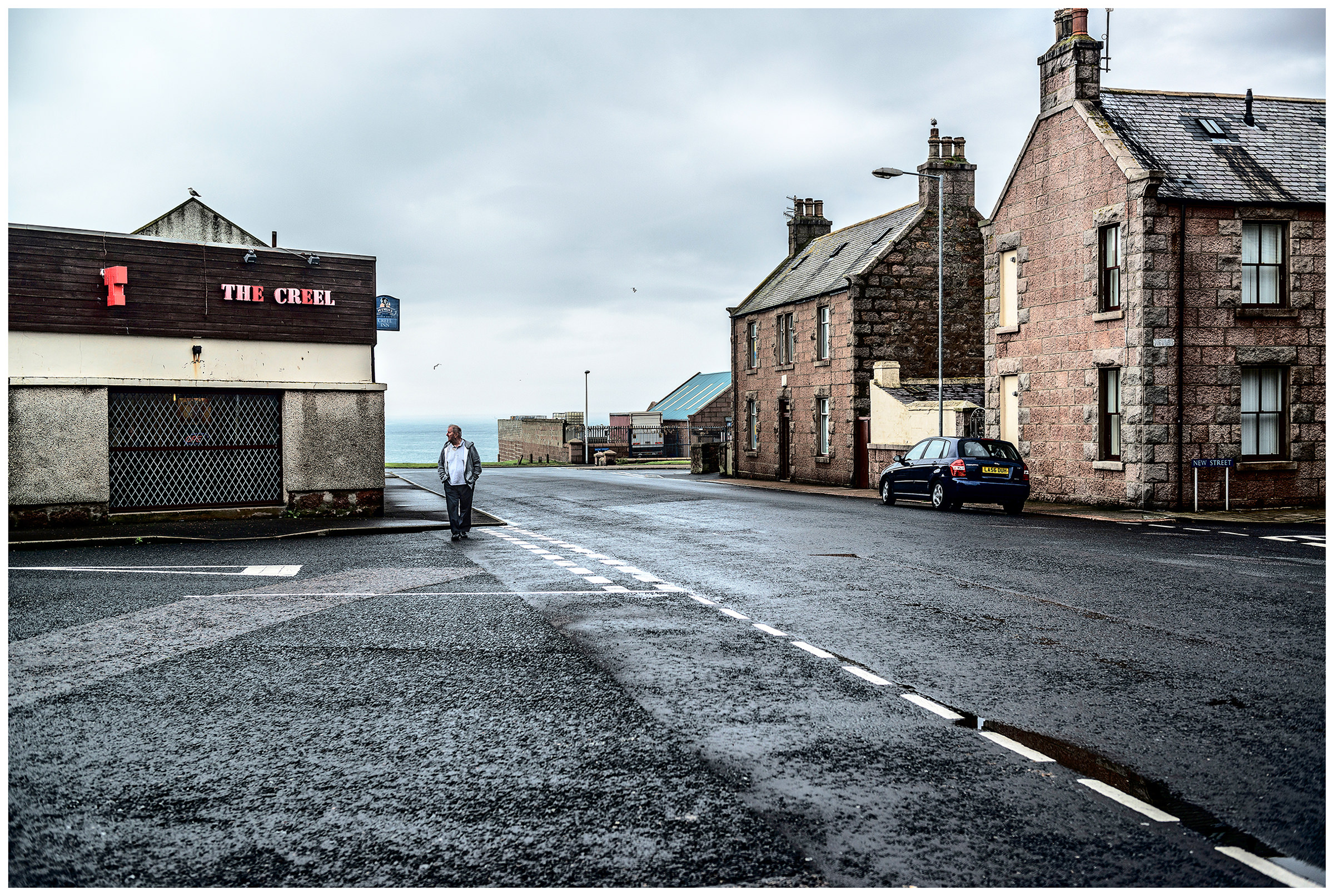 Scotland, Peterhead. A man walks through a street.
