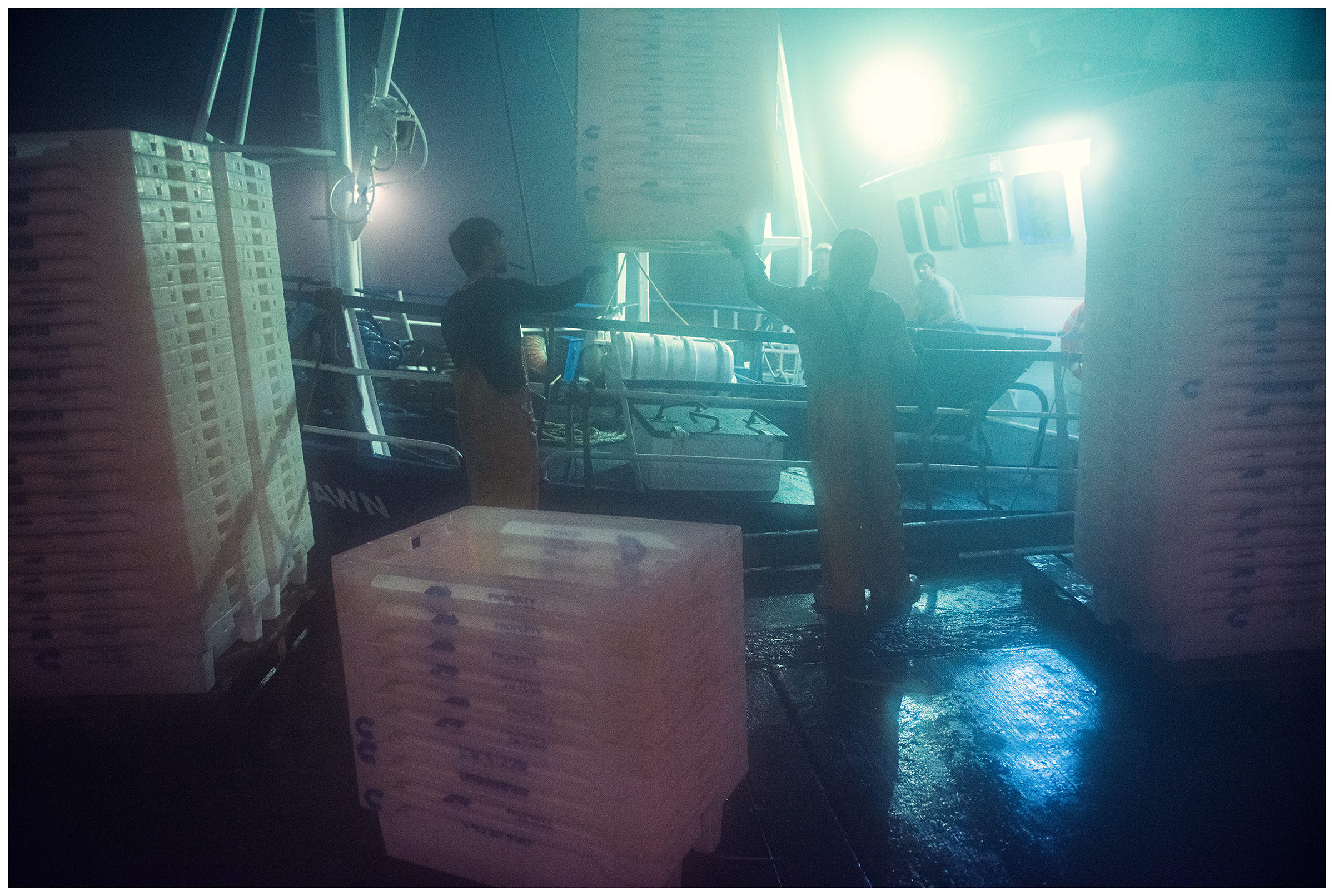 Scotland, Peterhead. The dock workers load empty plasticists onto a ship.