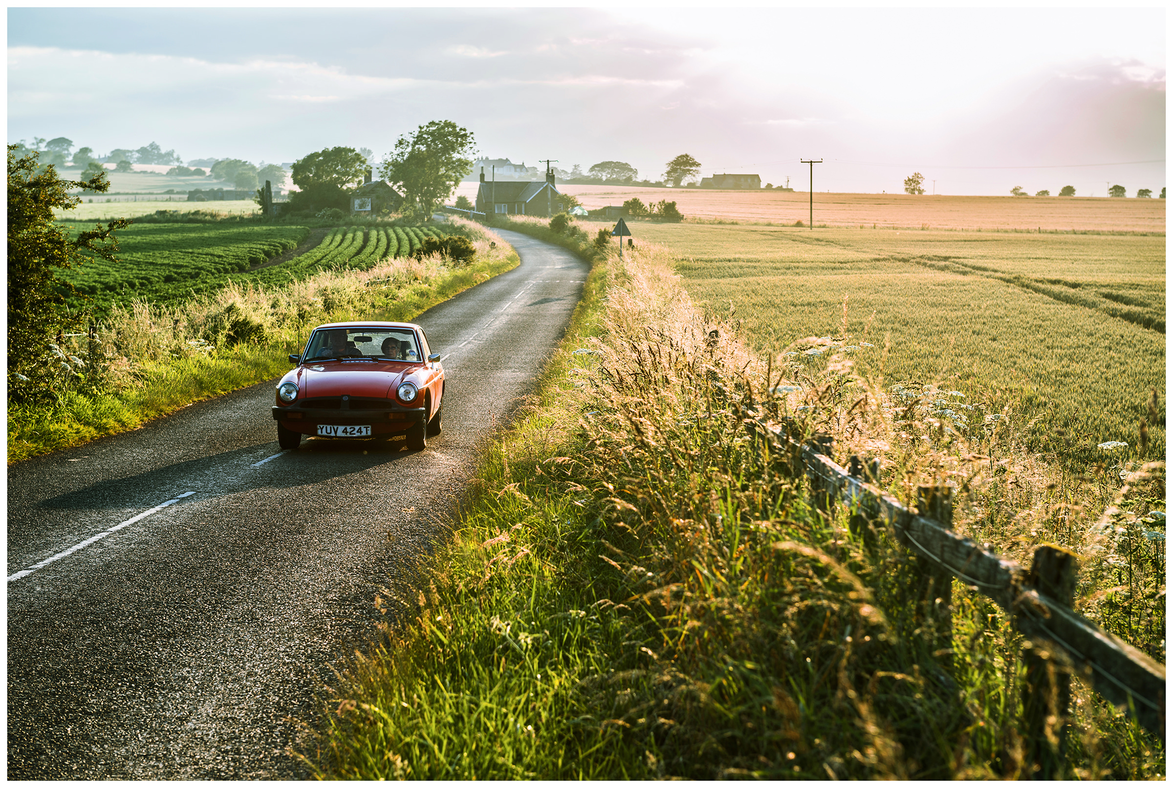 Scotland, Usan Montrose. A red car drives between the fields.