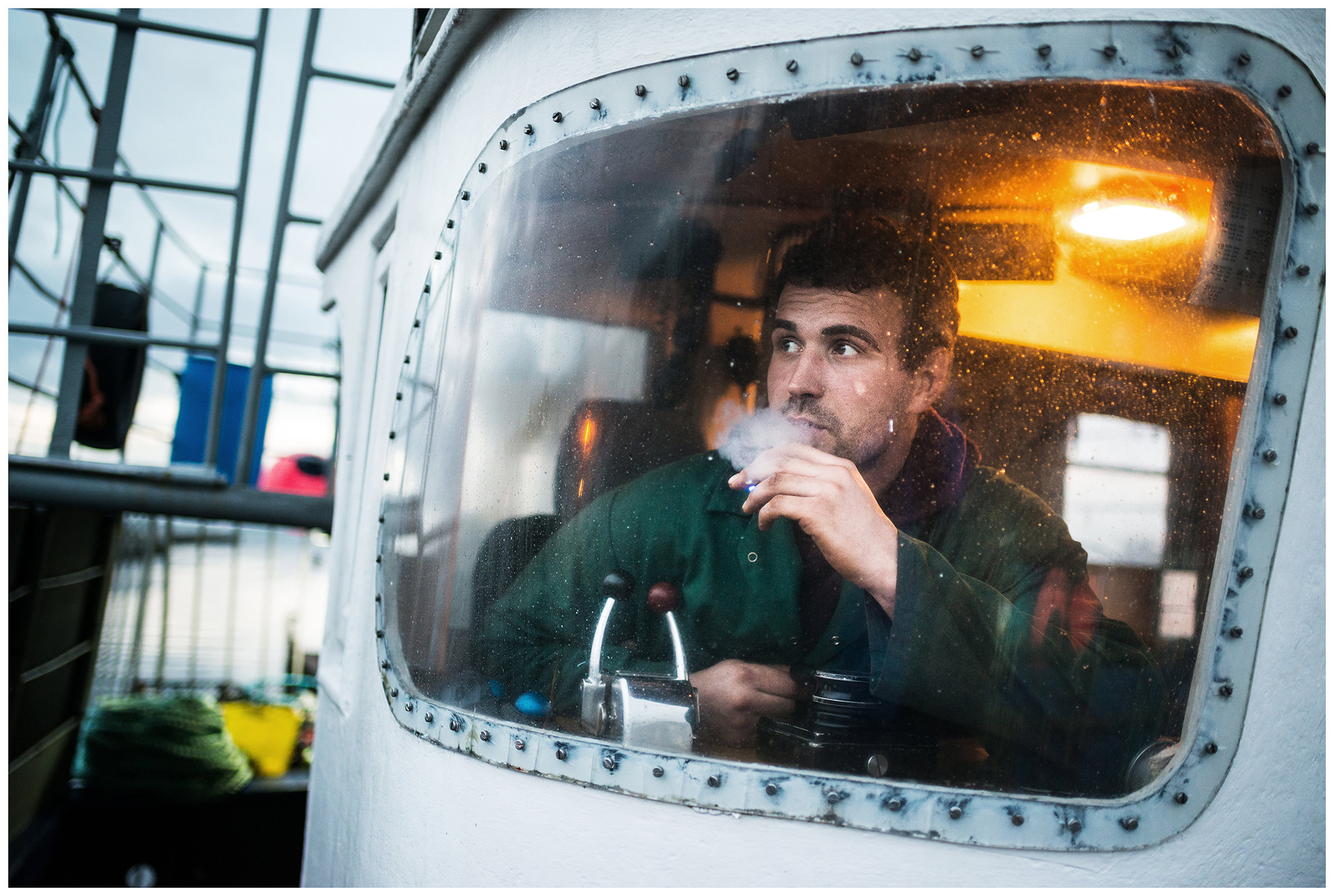Scotland, Girvan, Ayrshire. A man smokes in the cabin of a ship.