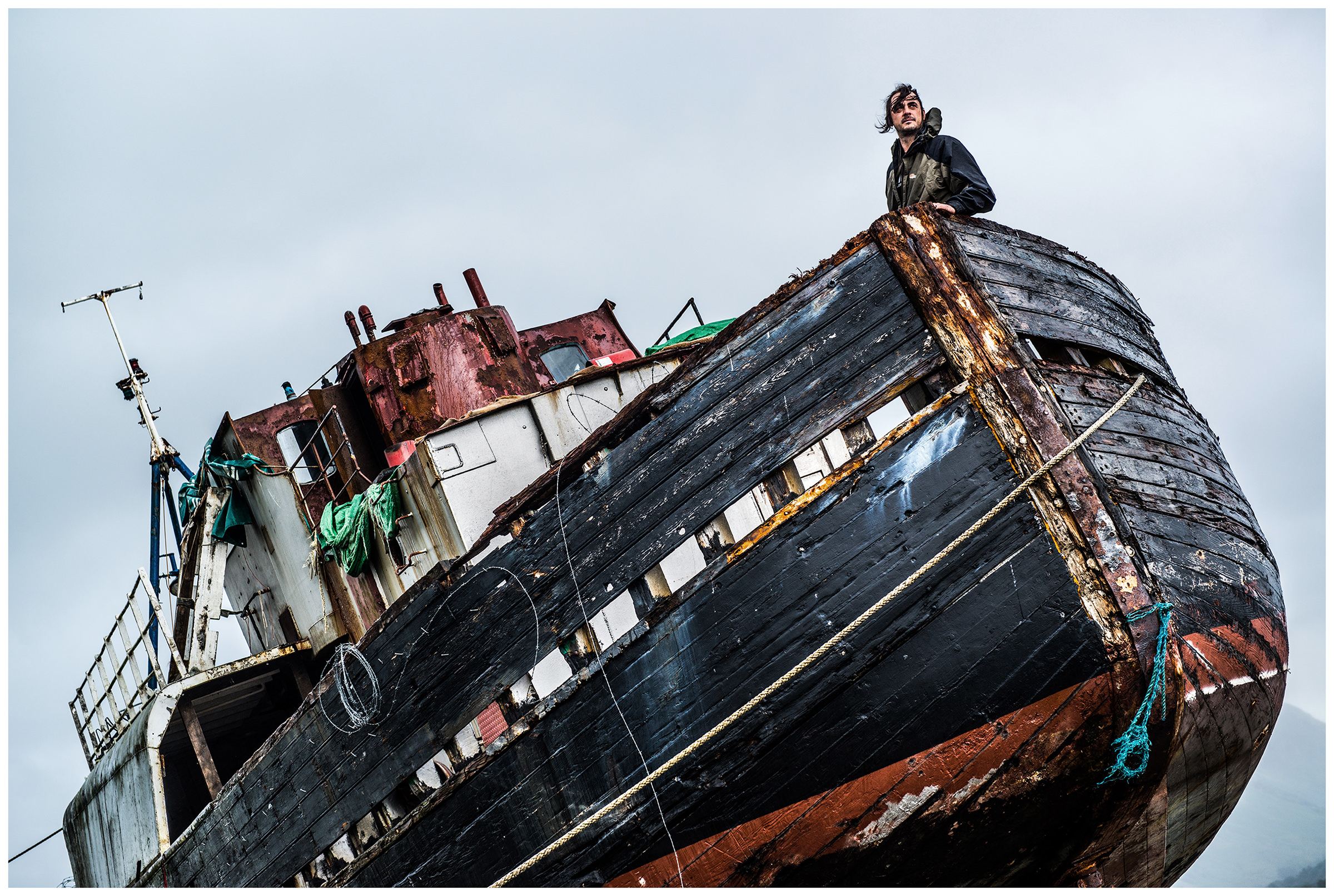 Scotland, Fort William. A man is standing aboard a shipwreck on the coast of Scotland.