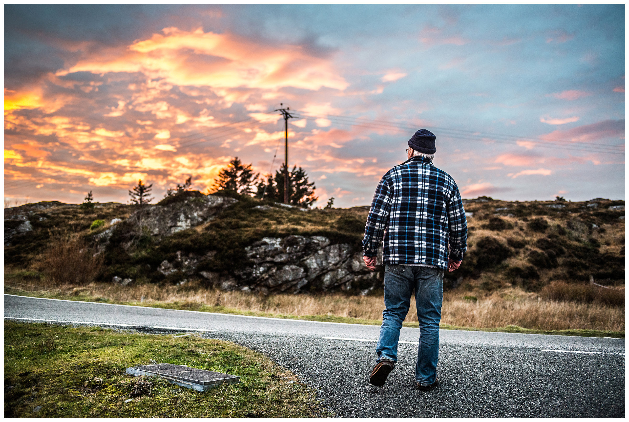 Scotland, Isle of Harris. A man walks towards sunset.