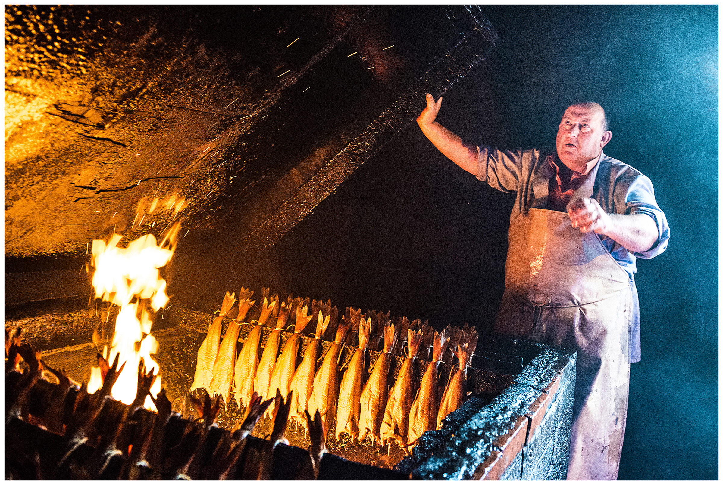 Scotland, Arbroath. The employee of a fish smokehouse smokes fish.