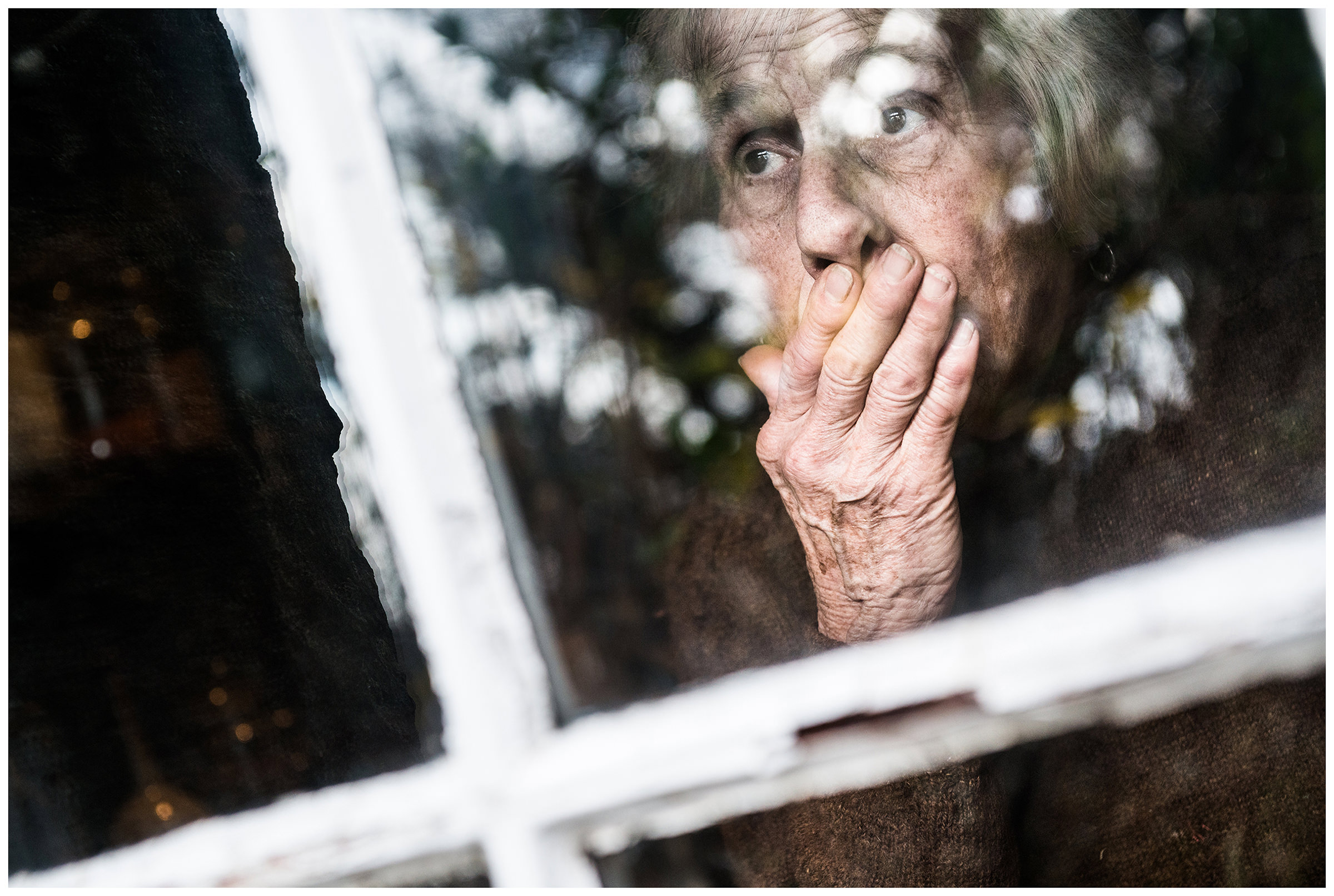 Scotland, Isle of Skye. An old woman looks out the window.
