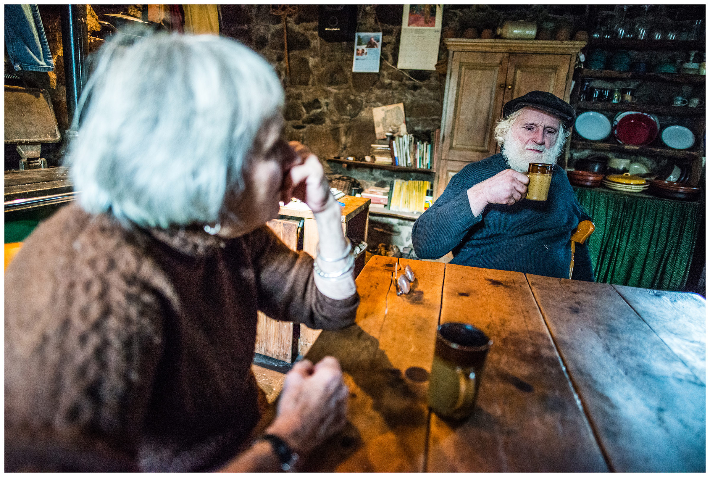 Scotland, Isle of Skye. An old woman and her husband sit at the table and drink coffee.