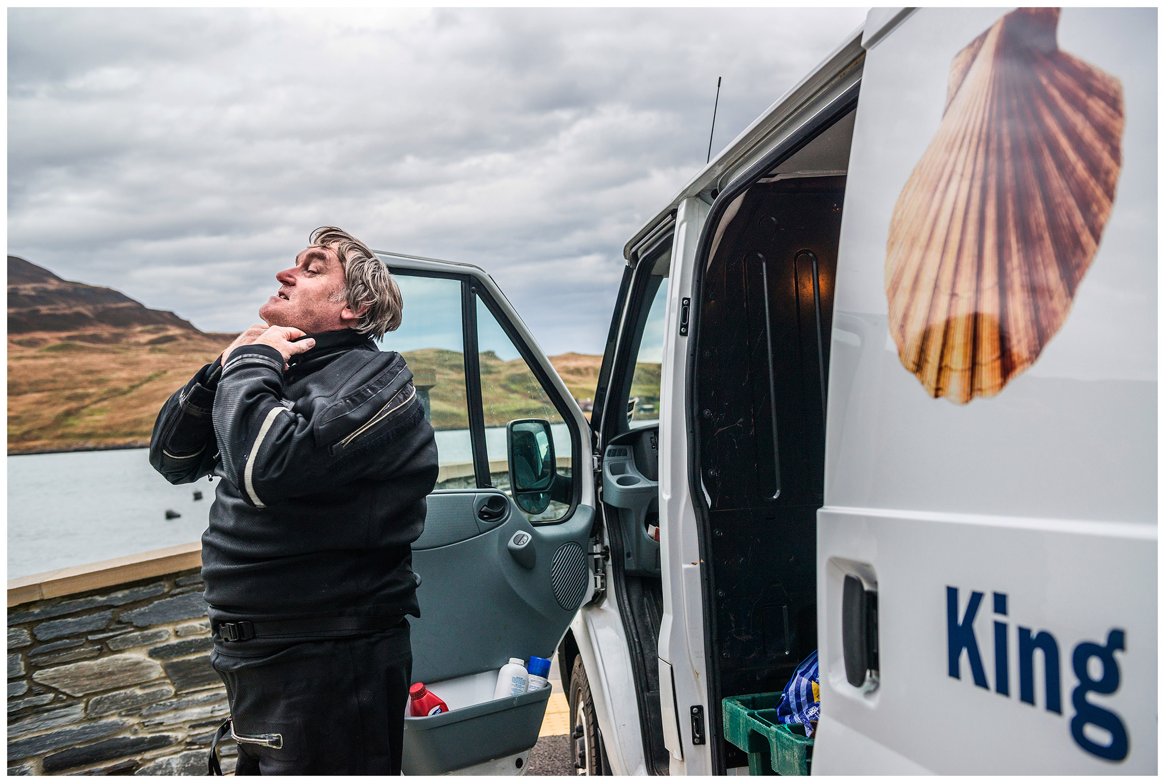 Scotland, Isle of Skye, Sconser. A scallop collector puts on his diving suit.