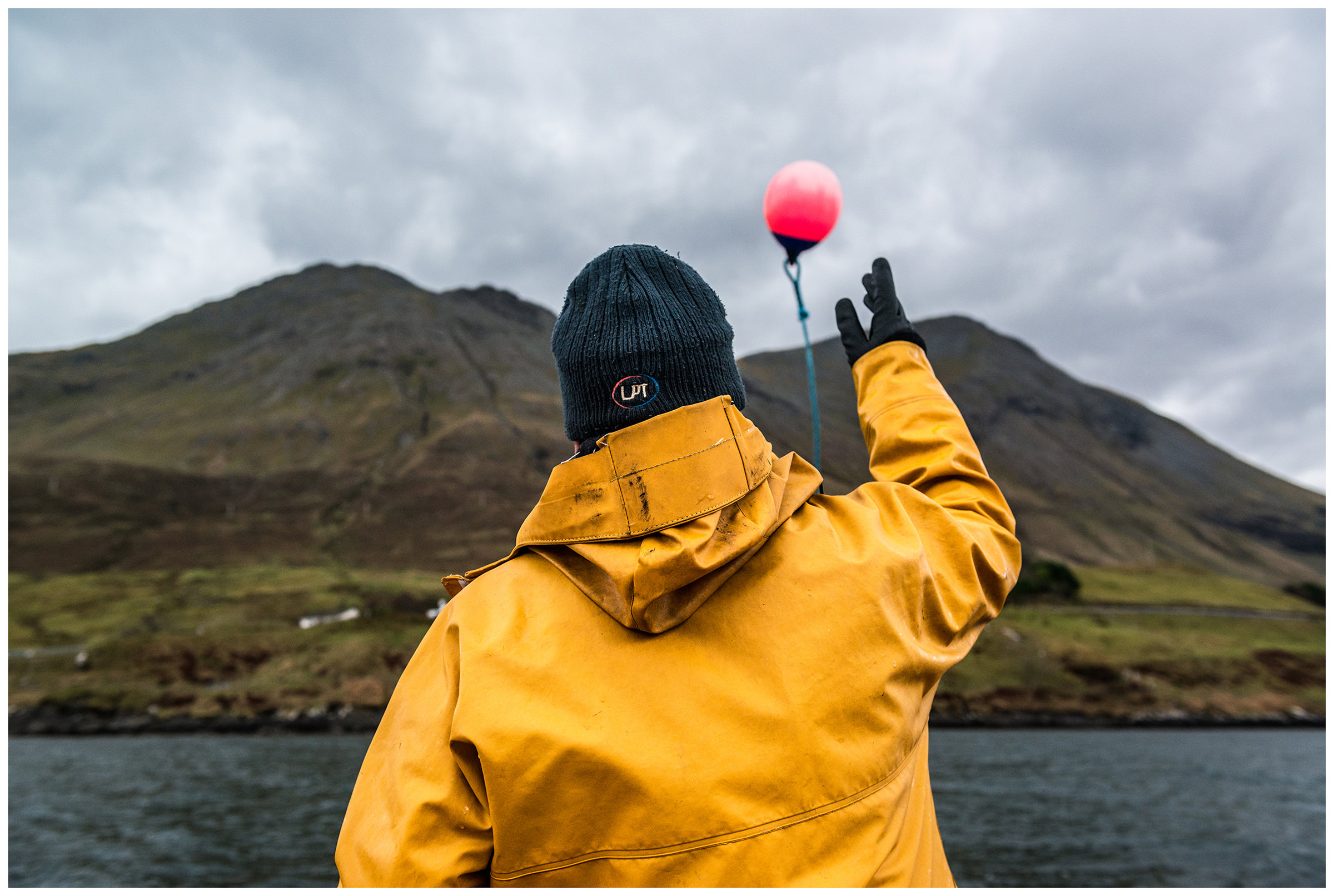 Schottland, Isle of Skye, Sconser. Ein Tiefseefischer wirft einen Schwimmer ins Wasser.