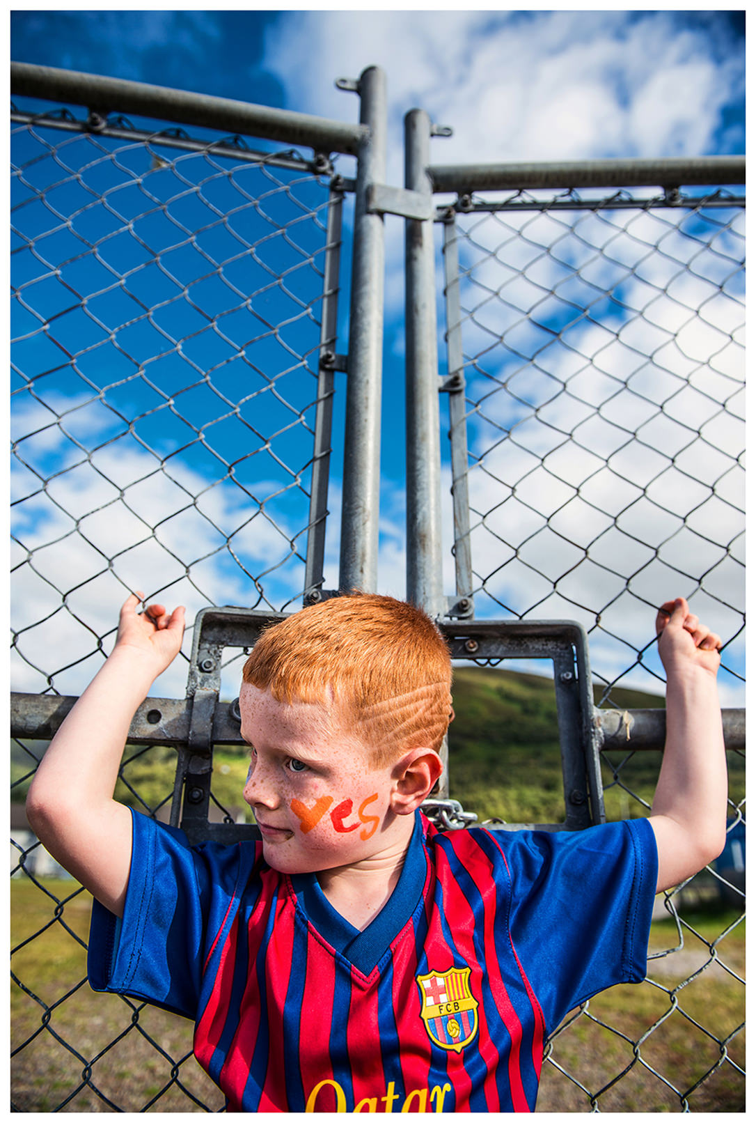 Scotland, Fort William. A boy stands in front of a fence. In 2014, a referendum on Scotland's independence took place in Scotland. The activists of the independence movement therefore organized big celebrations in which many children took part.
