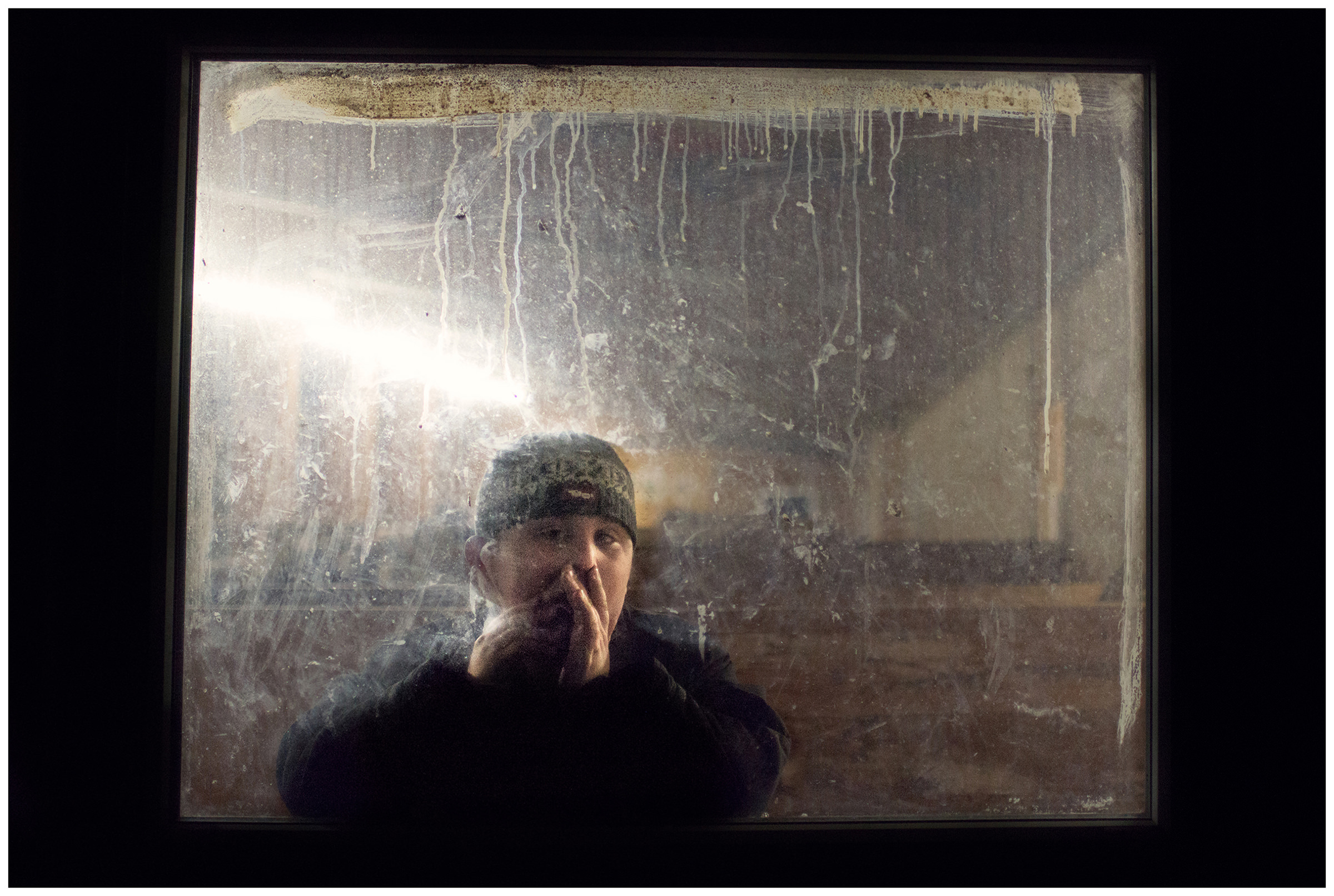 Padaun, Varseltal, Wipptal, North Tyrol, Austria. The son of a farmer looks through the window in the stable.