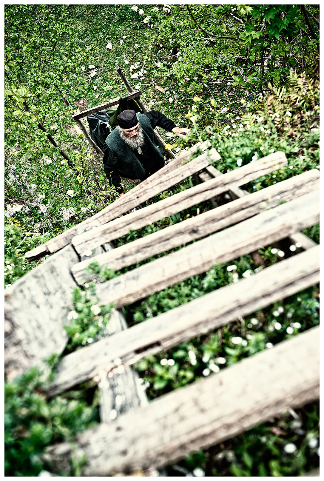 Imereti, Georgia. The Georgian monk Maxime Kavtaradze climbs a wooden ladder to his house on a rock.