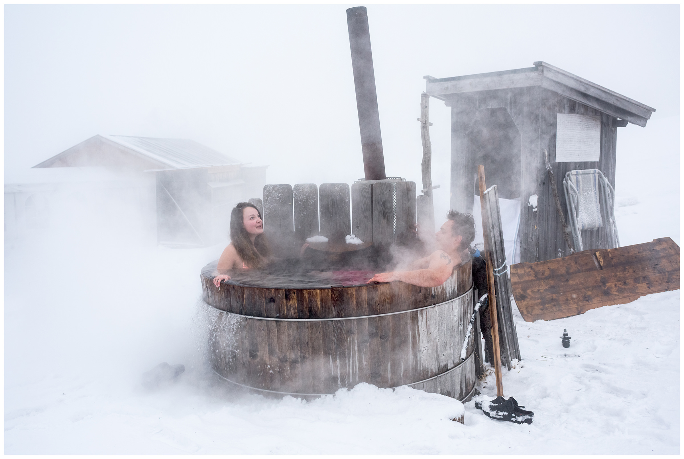 Sattelbergalm, Wipptal, North Tyrol, Austria. A couple bathing in a hot tub.