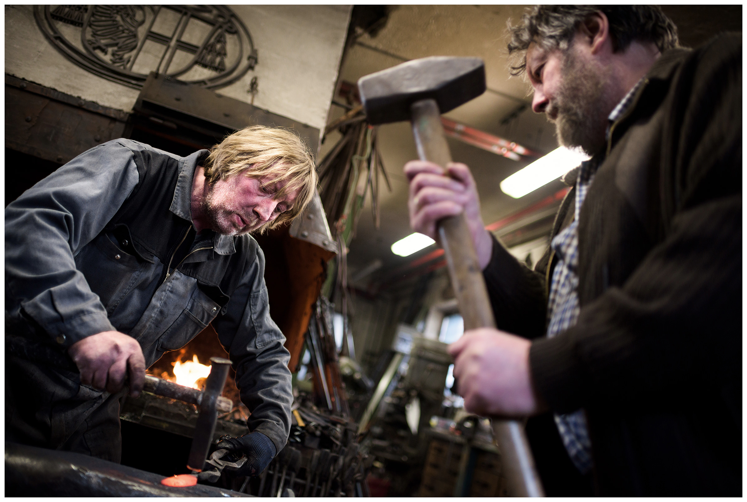 Wipptal, North Tyrol, Austria. A blacksmith and his brother work in their smithy.