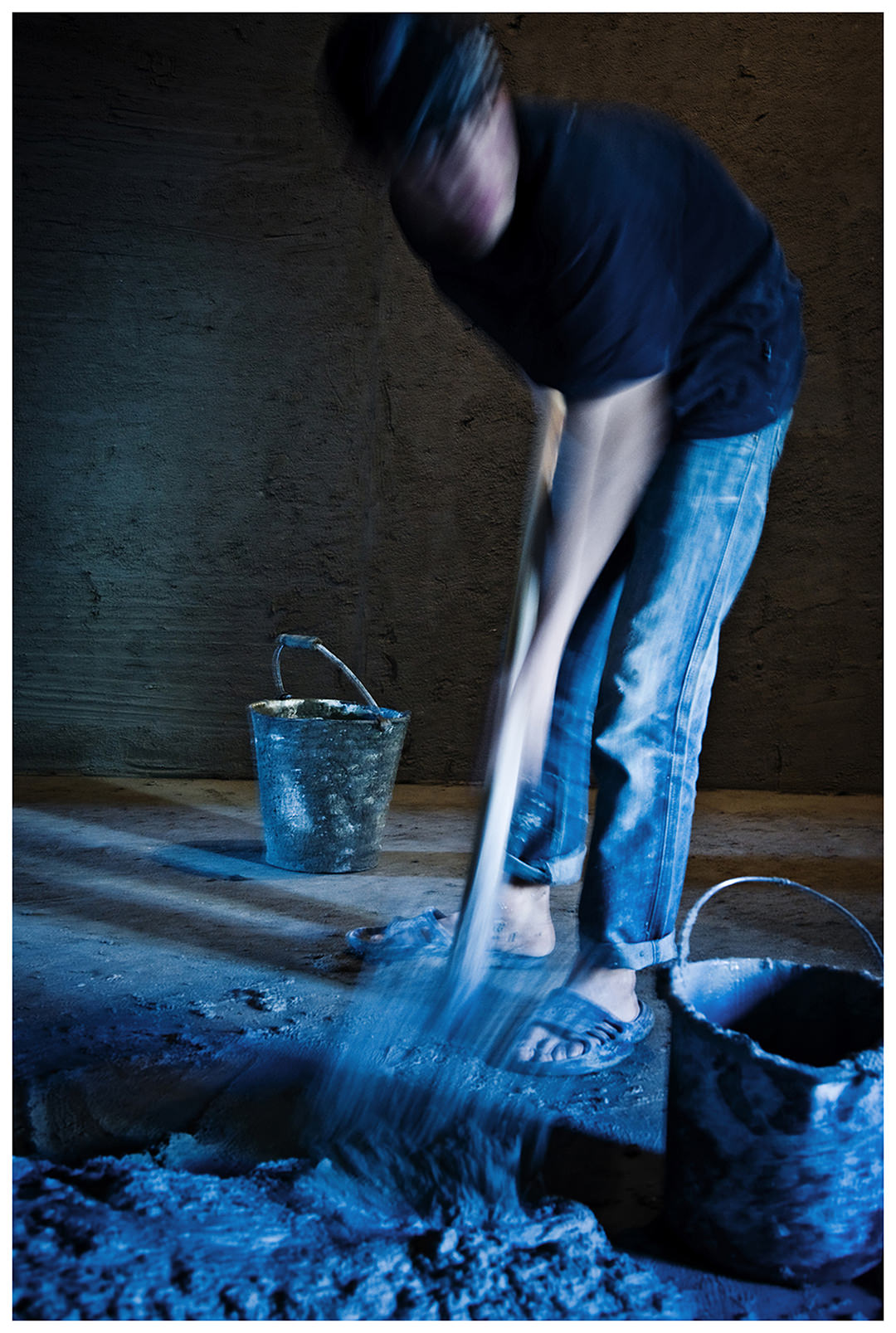 Saint Petersburg, Russia. An Uzbek guest worker shovels cement at a construction site.
