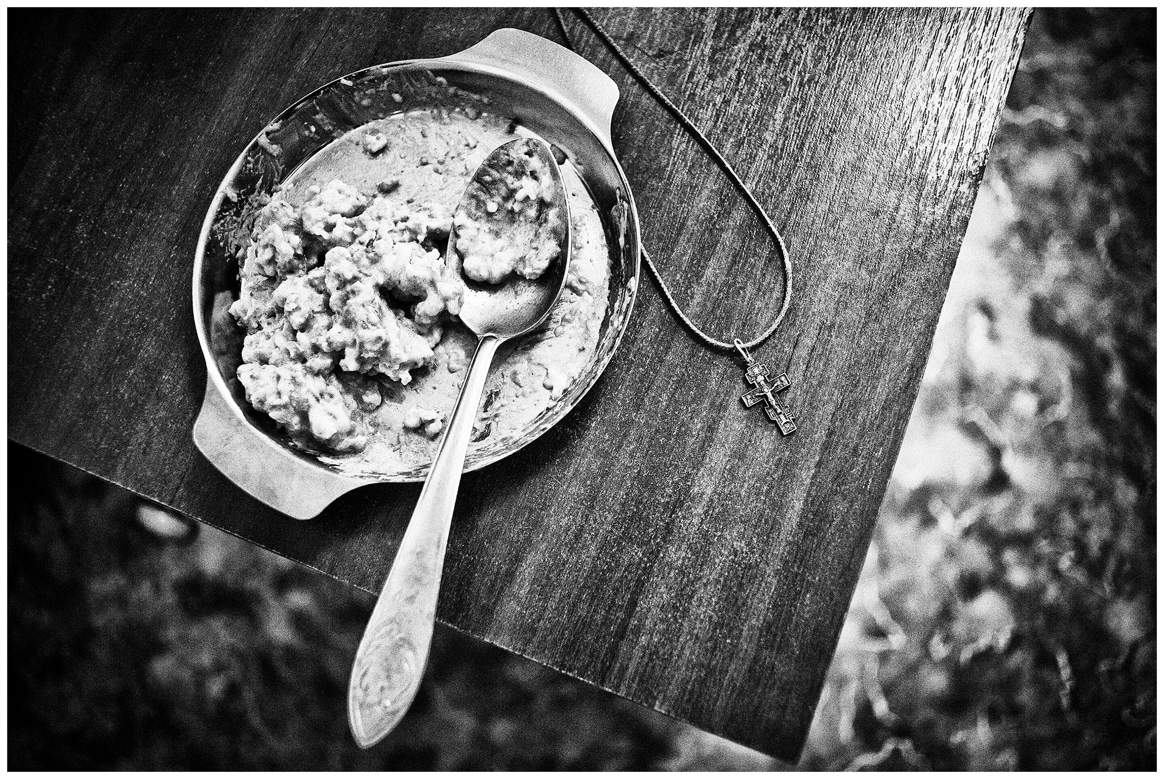 Minsk Hospice, Minsk, Belarus. A cross lies next to a plate with food leftovers on a bedside table.