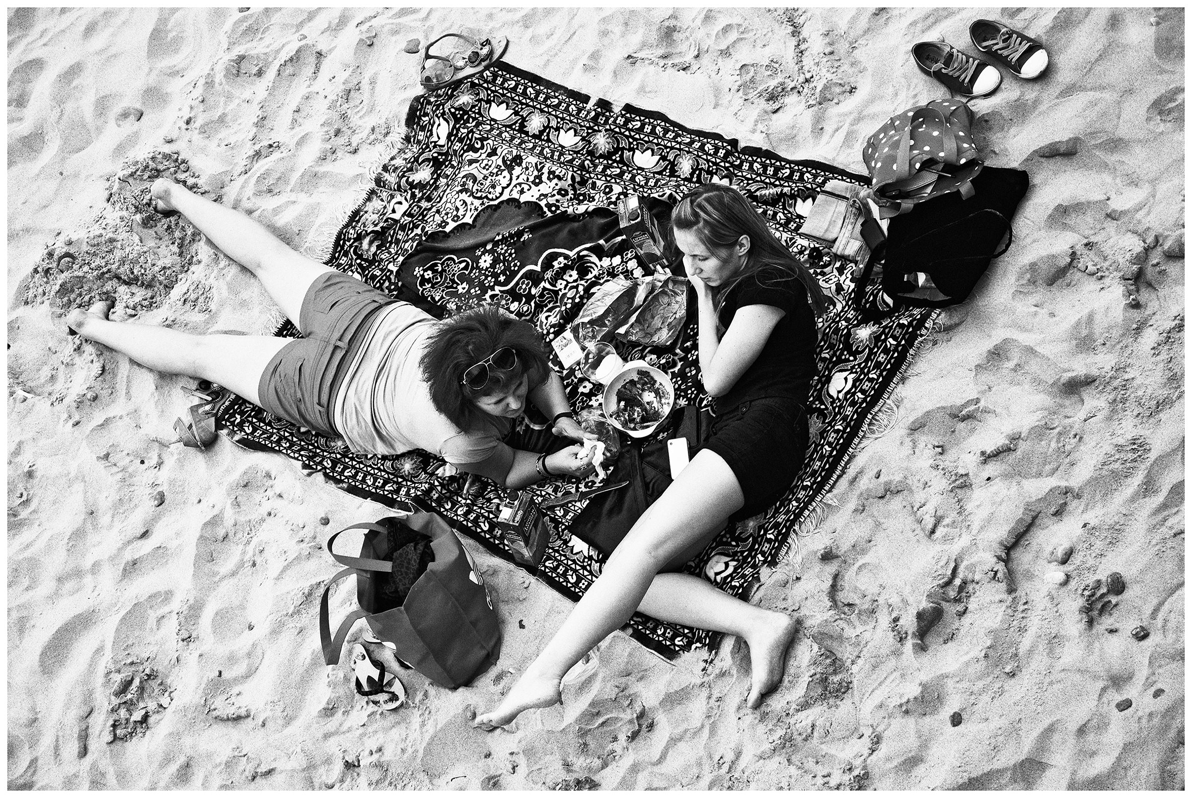 Kaliningrad, Russia. Two young women sunbathe on a carpet in Sveltogorsk.