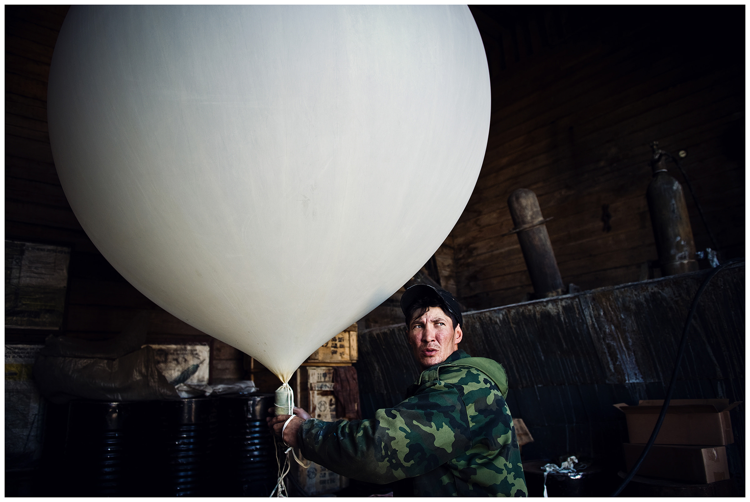 Shoyna village, Russia. A meteorologist blows up a probe.