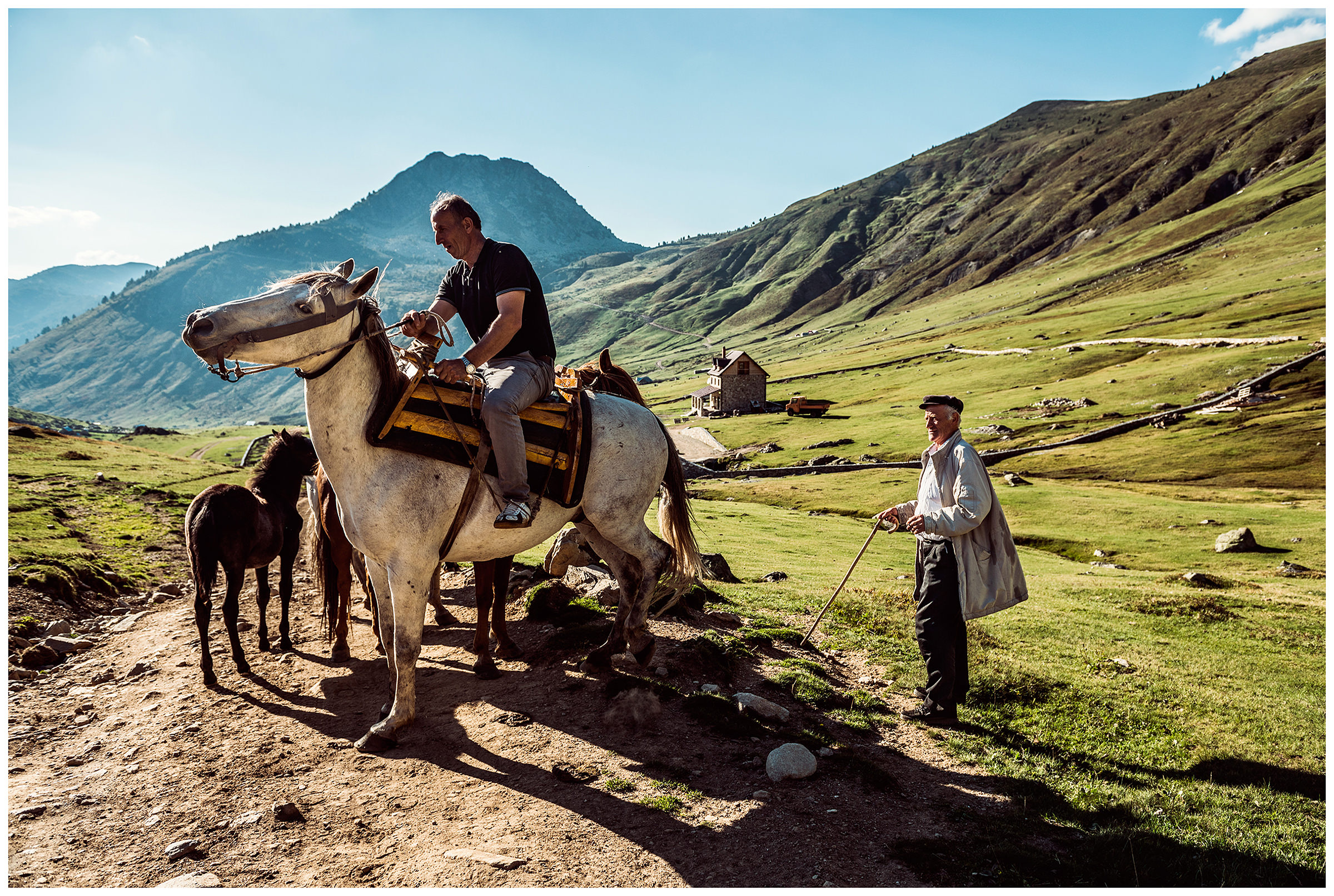 Doberdol, Albania. A man on a horse in the mountains talks to another villager.