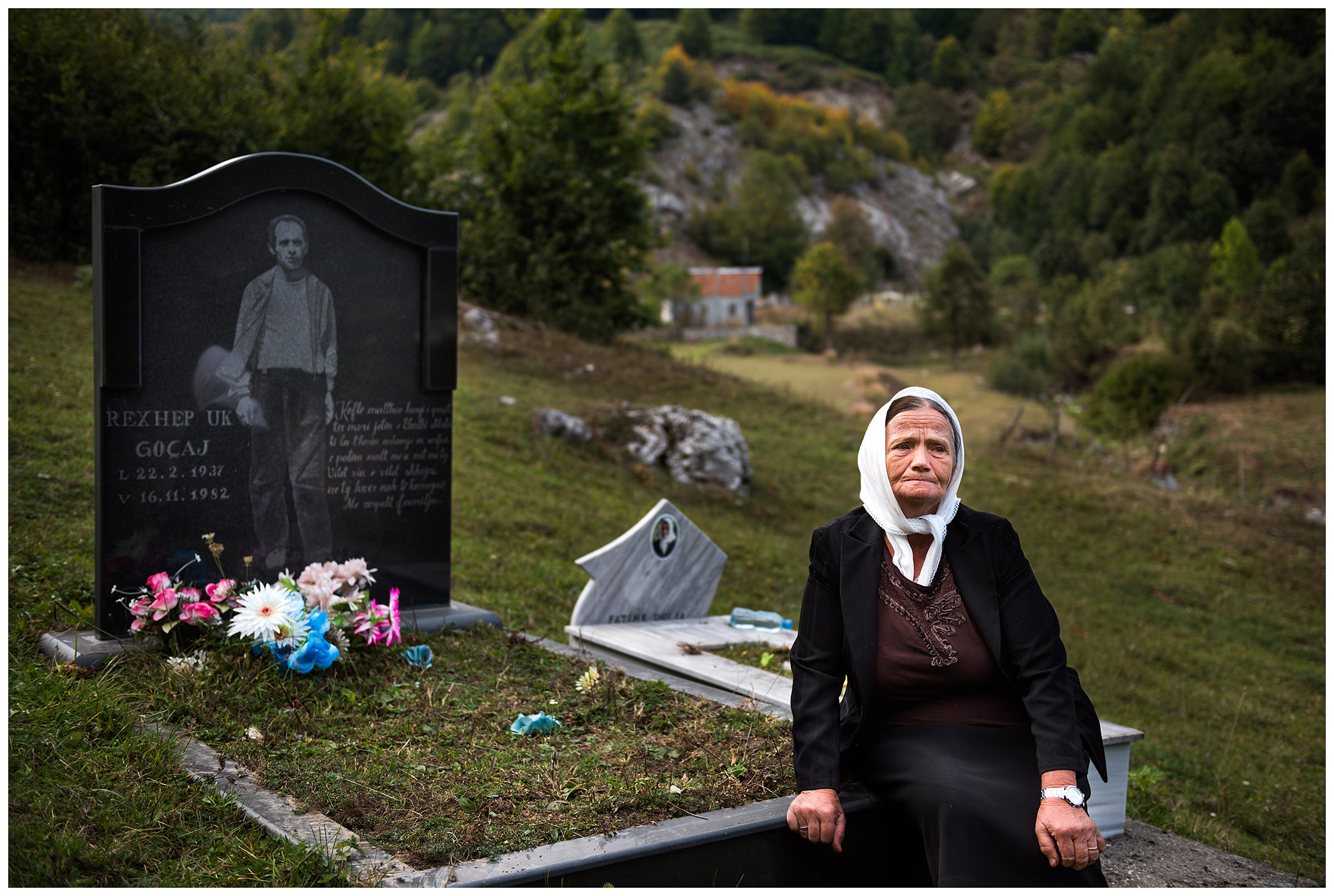 Cerem, Albania. An old woman is sitting at her husband's grave in the mountains. The man is a victim of the Hoxha regime.