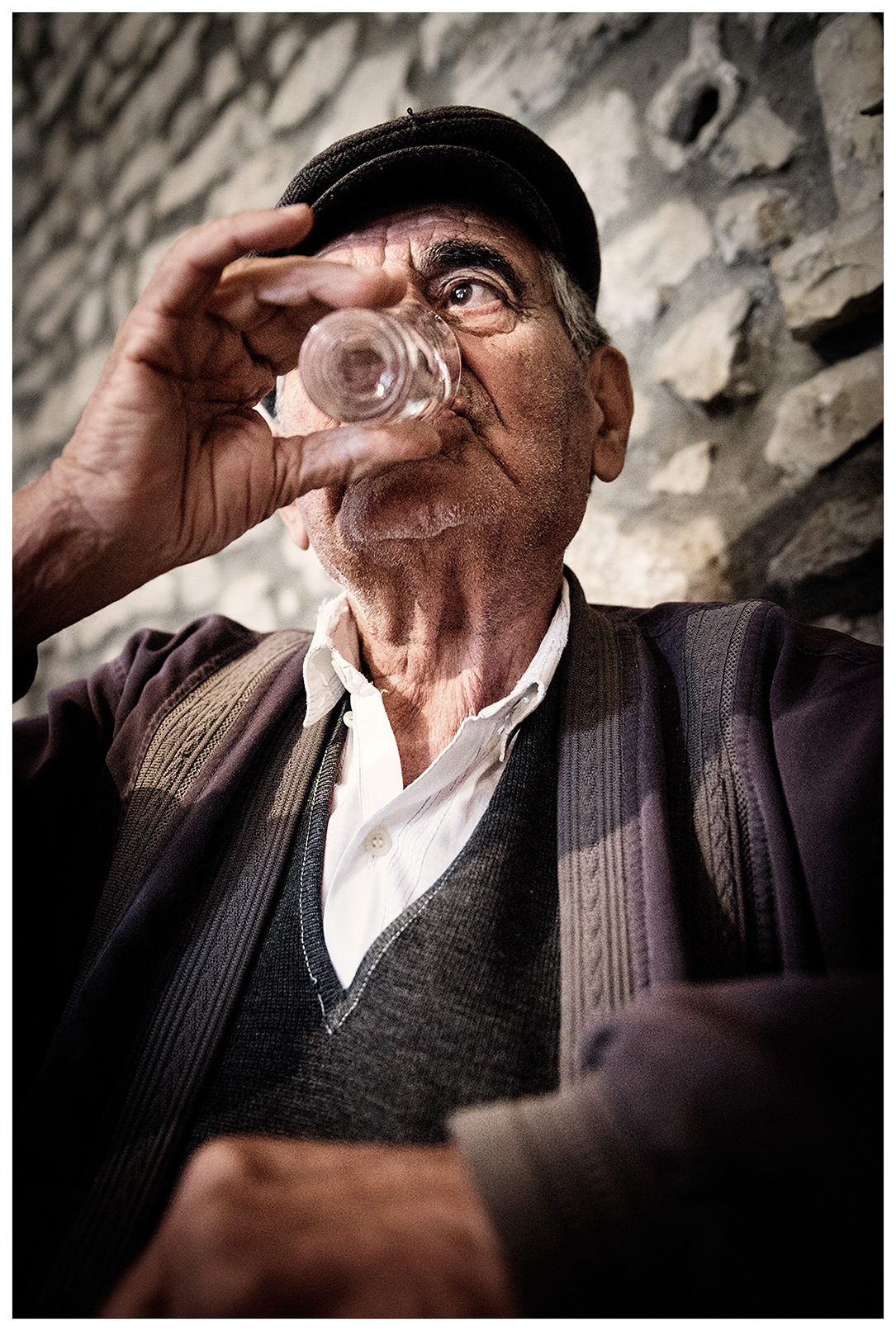 Albania, Queparo. A man drinks raki in his son's pub.