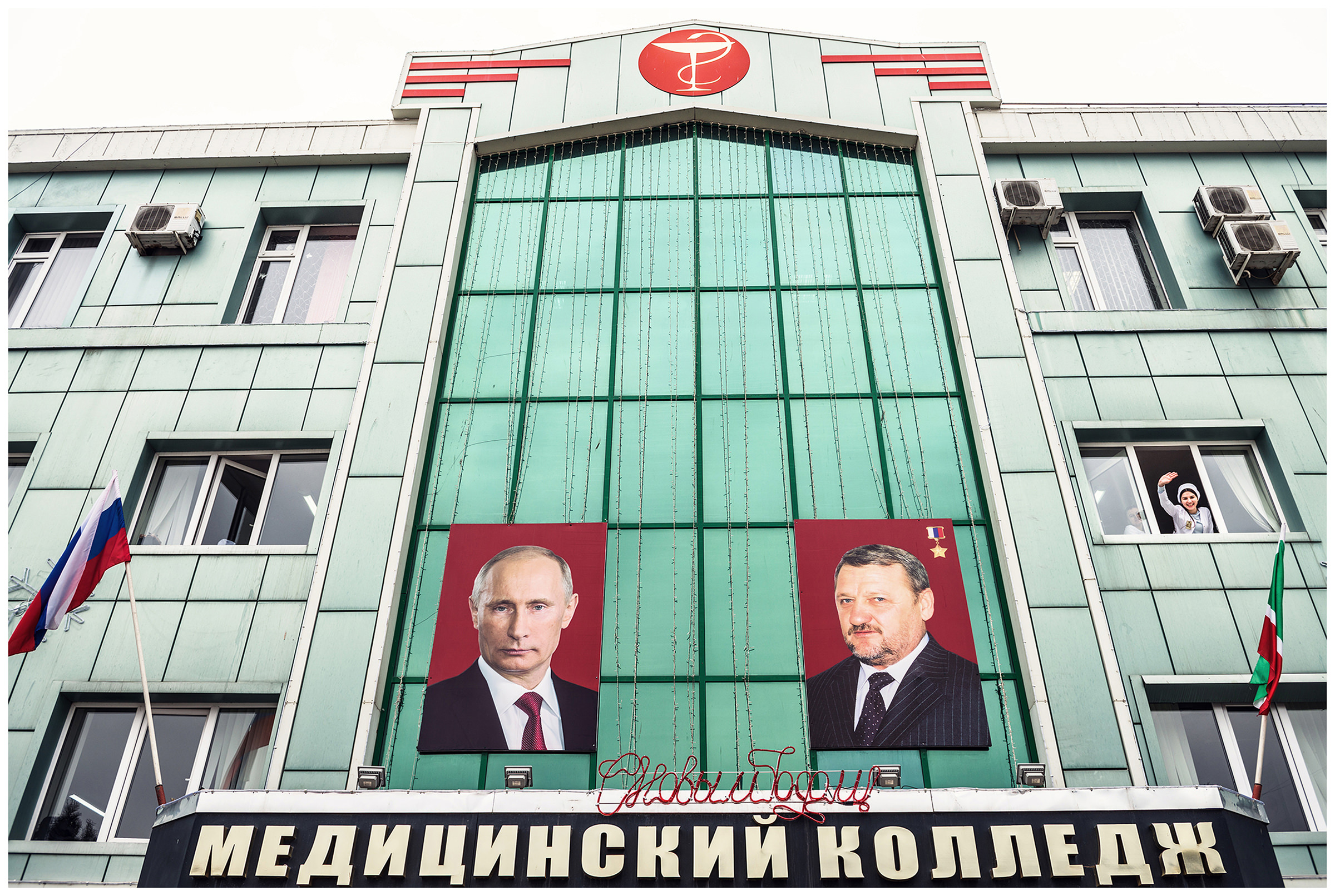 Grozny, Chechnya, Russia. A young woman waves to her friend from the window of the medical school in Grozny.