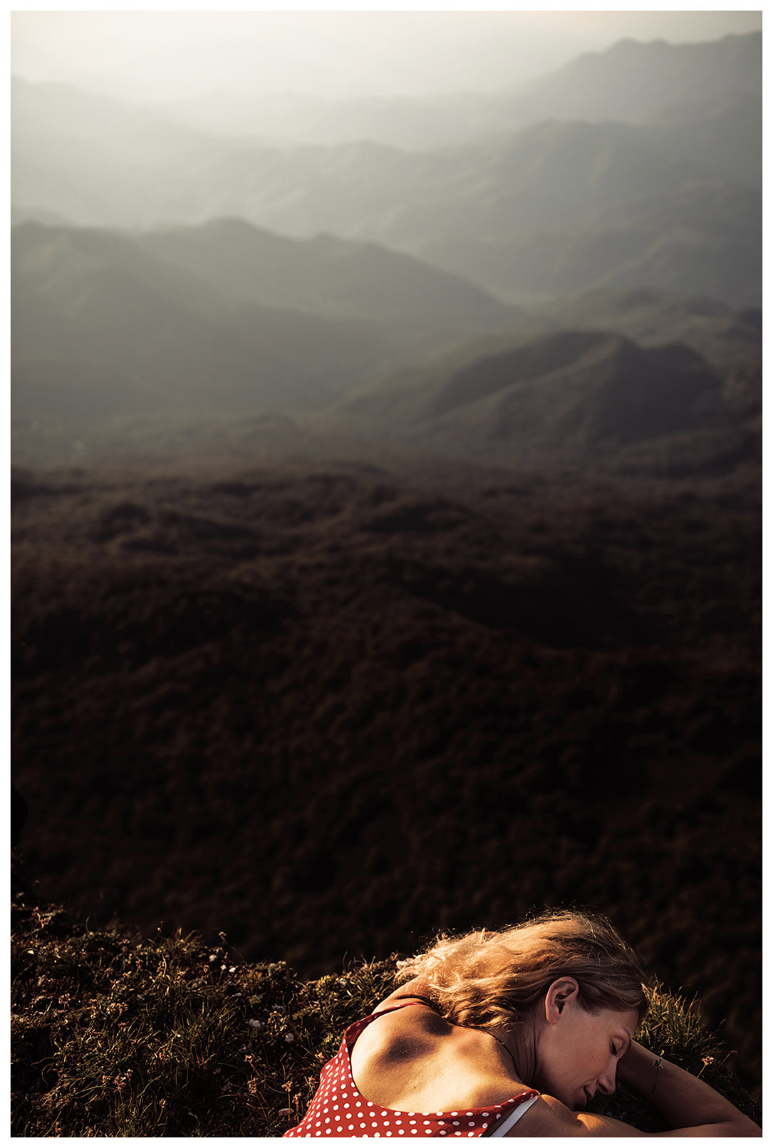 Shkmeri, Racha, Georgia. A woman relaxing on a rock at sunset.