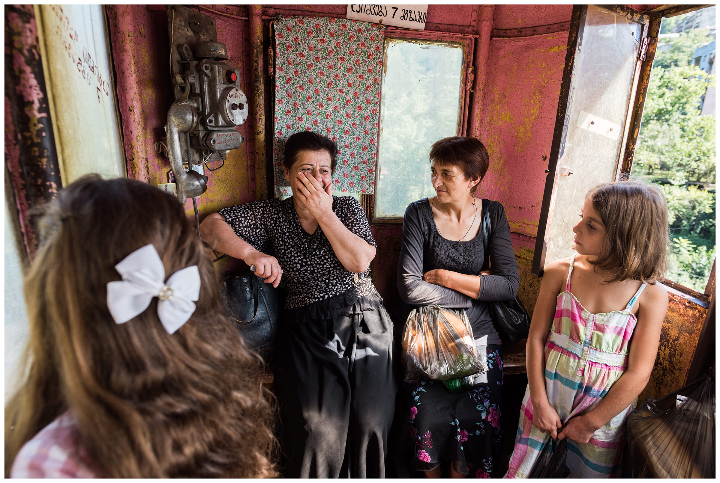 Chiatura, Imeretia, Georgia. Passengers of a cable car gondola accompanied by a cable car employee ride up a mountain. The gondola of the cable car in Tschiatura is often referred to as the "iron coffin".