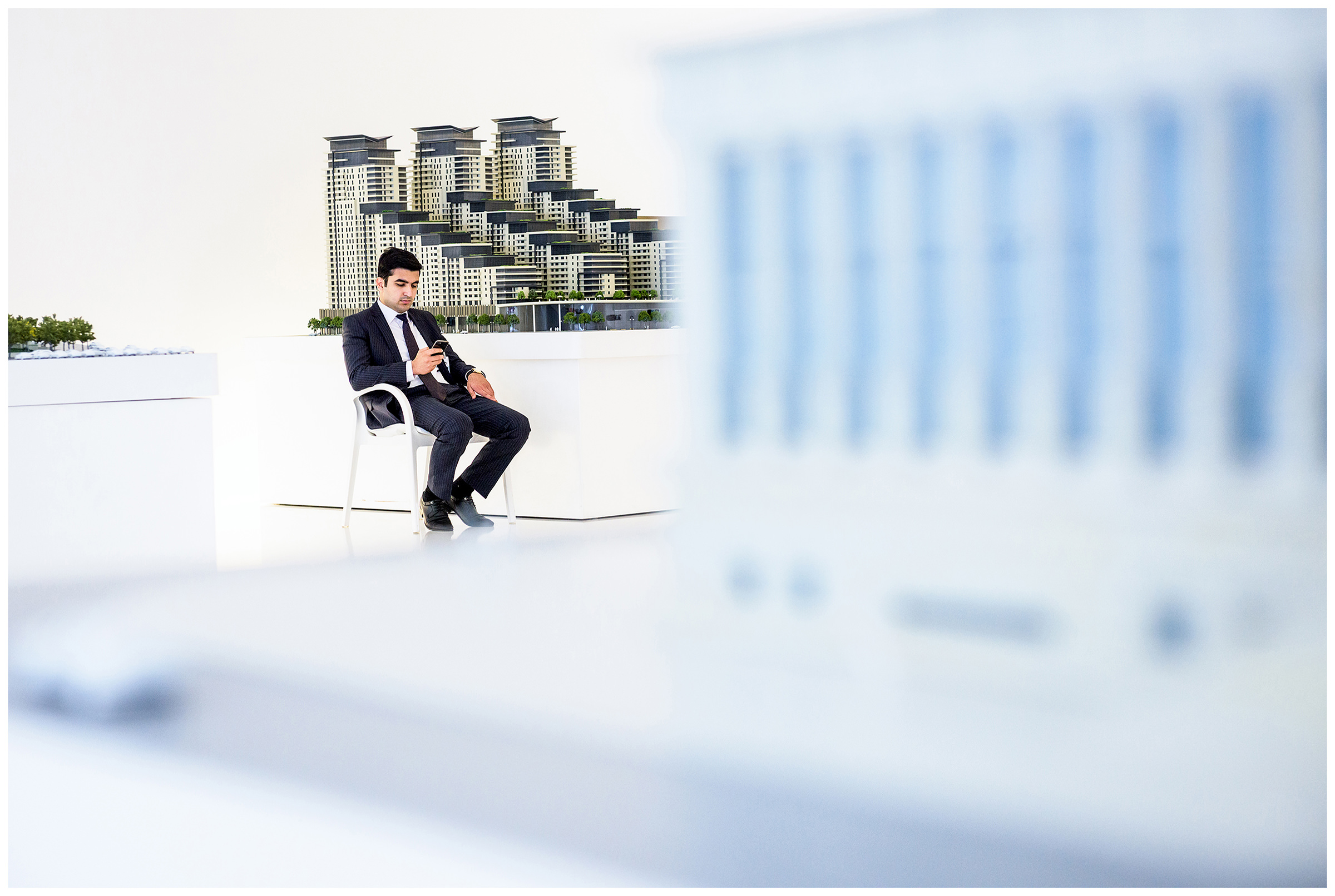 Azerbaijan, Baku. A security guard in front of a Baku miniature town in Aliyev Museum in his smartphone.