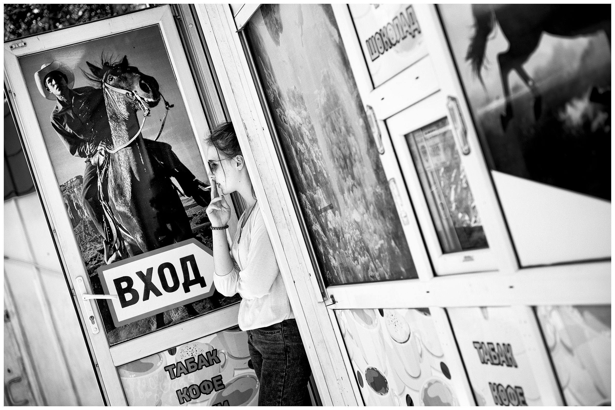 Sevastopol, the Crimea. A woman smoking at a drugstore entrance.