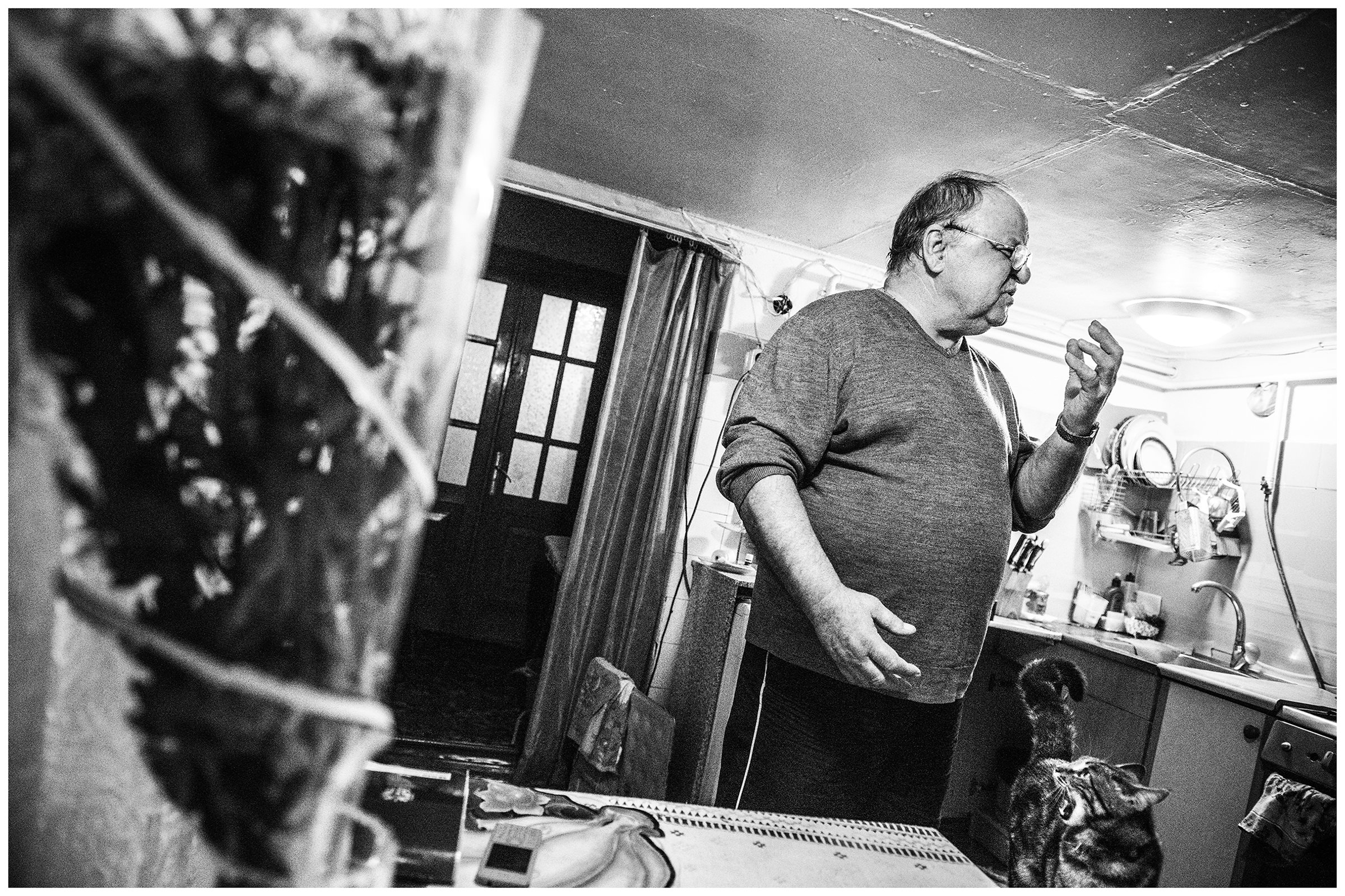 Yalta, the Crimea. The former submarine radio operator stands in his kitchen with his cat.