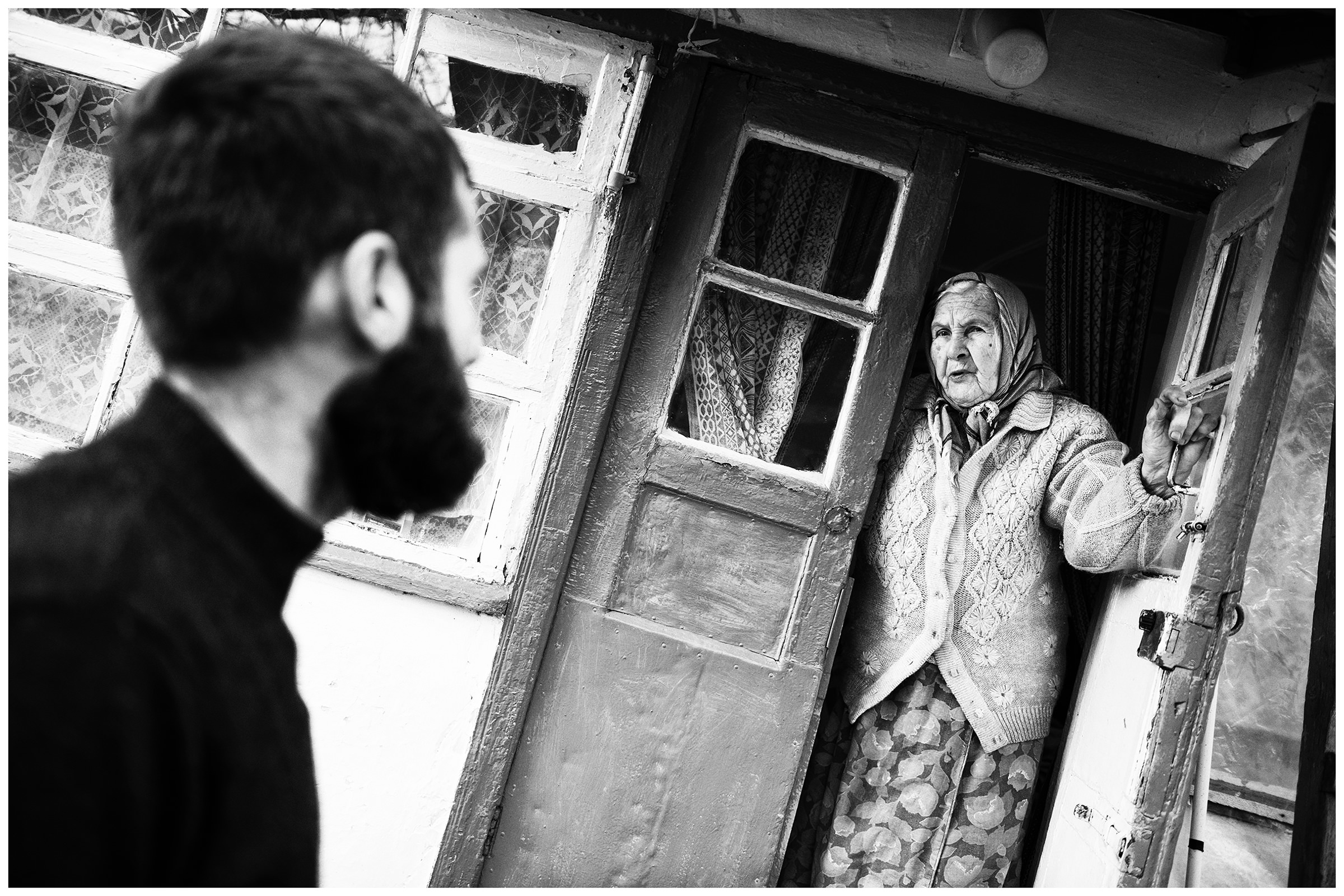 Village Mezhdurechye, Crimea. A Tatar man talks to an old Russian woman who lives in the house his grandfather built.