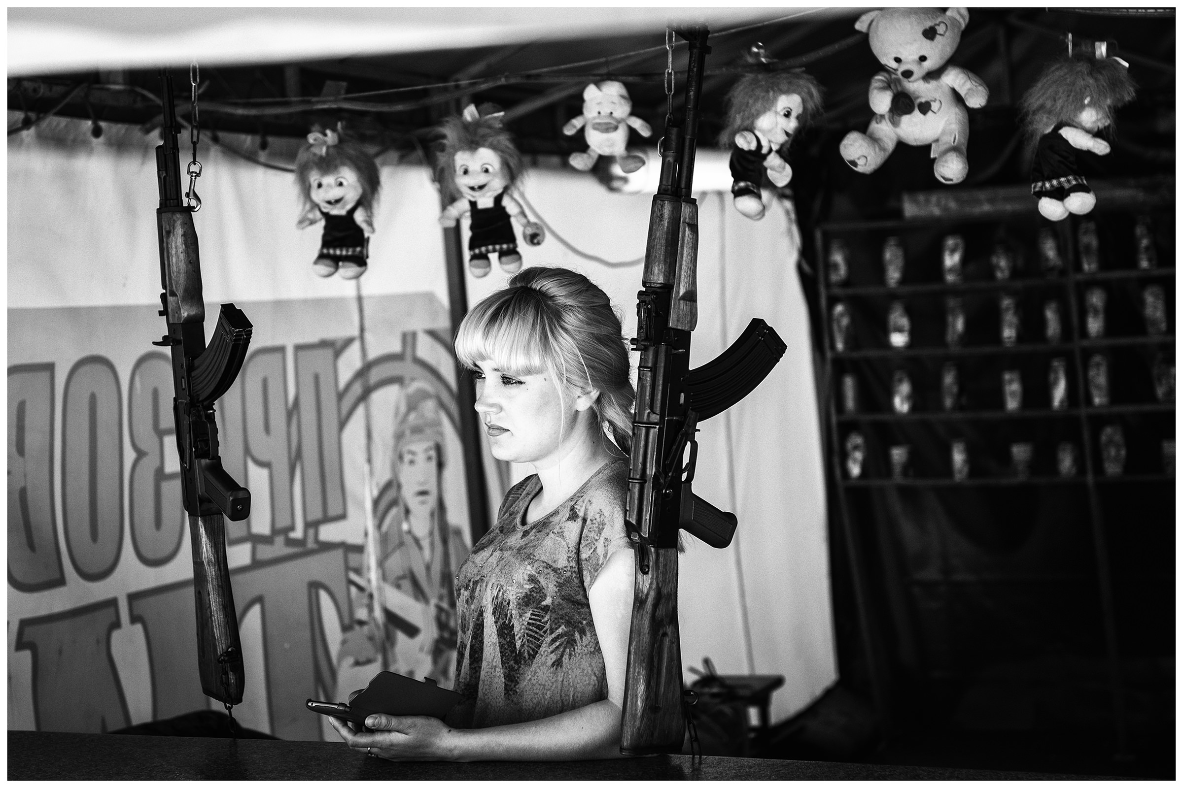 Balaklava, the Crimea. A woman is standing at a shooting range on the shore of the bay of Balaklava with a smartphone in her hand.