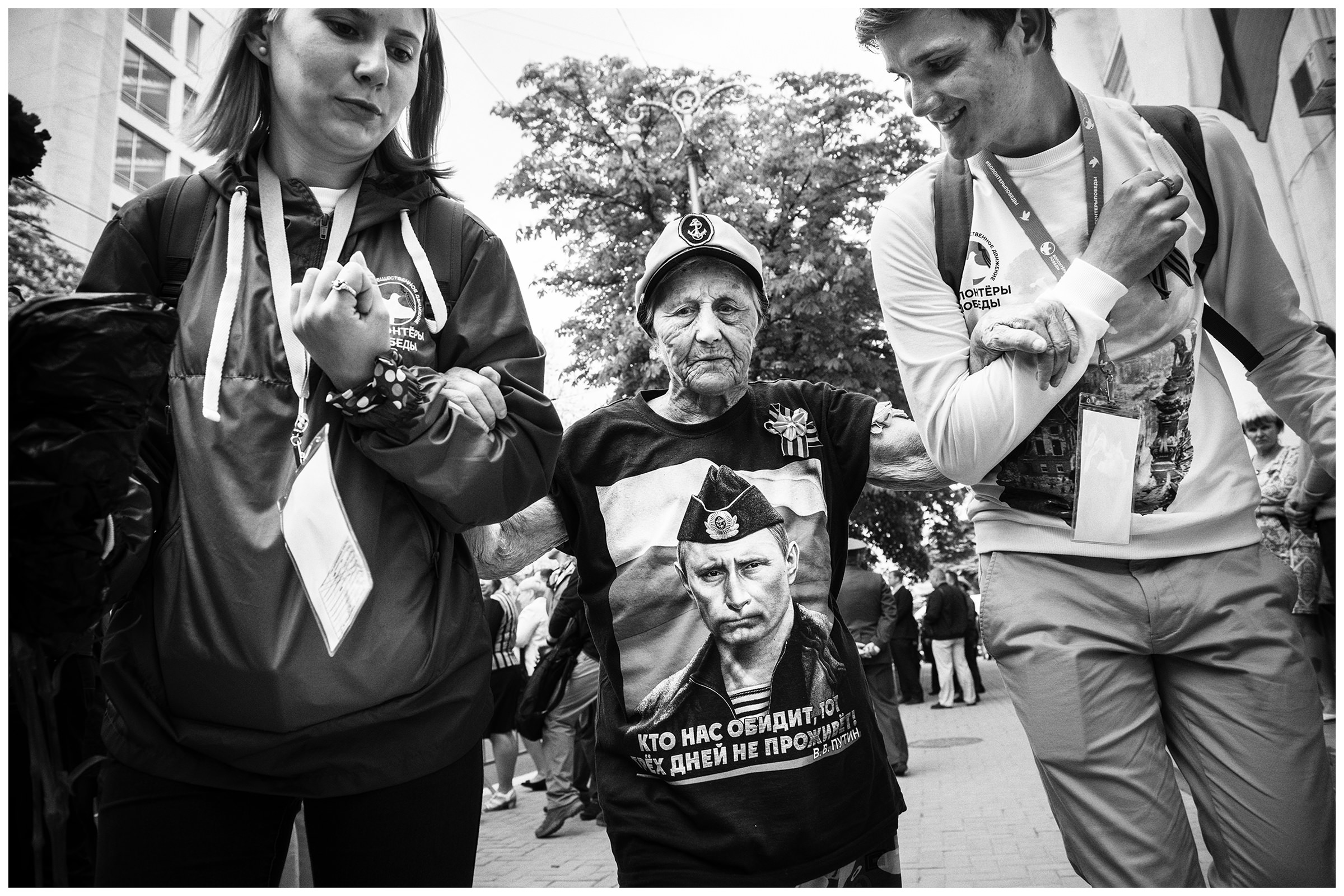 Sevastopol, the Crimea. A young woman and a young man help an old woman with a portrait of Putin on her T-shirt. The military parade takes place on the occasion of the victory over Nazi Germany on May 9.