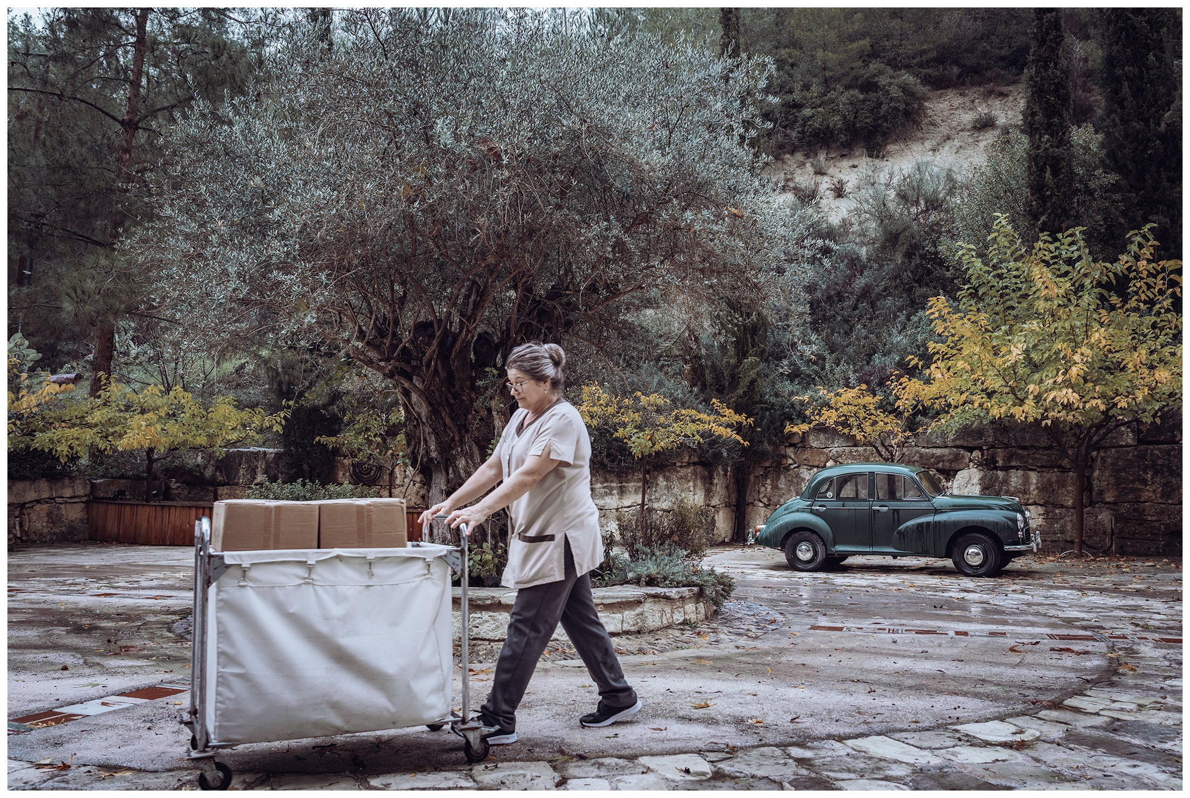 Miliou, Cyprus. An employee from the Secret Forest Wellness Retreat rolls a laundry cart through the yard.