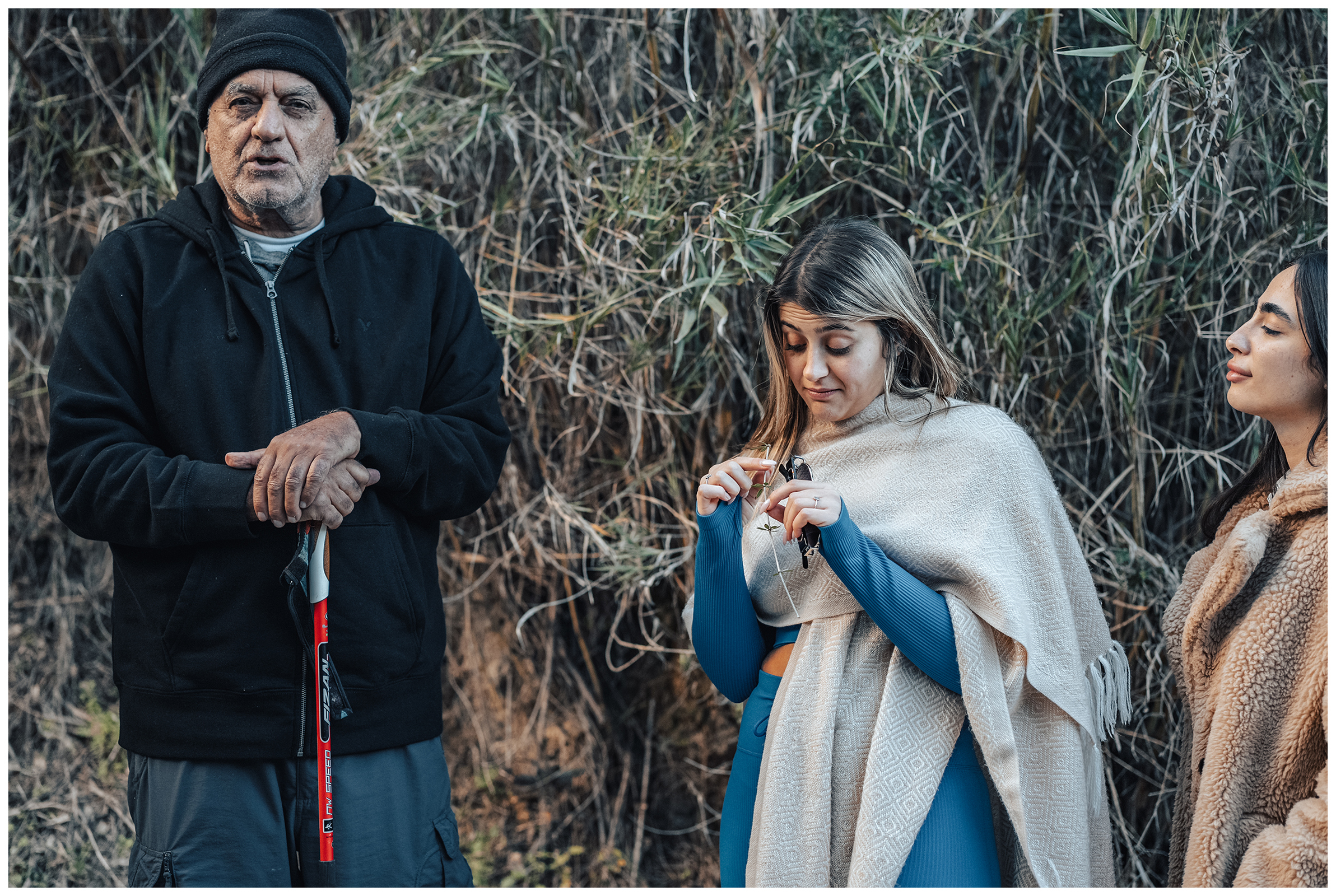 Miliou, Cyprus. An old man talks about the flora during a tour through a forest and two young Israelis listen to him.