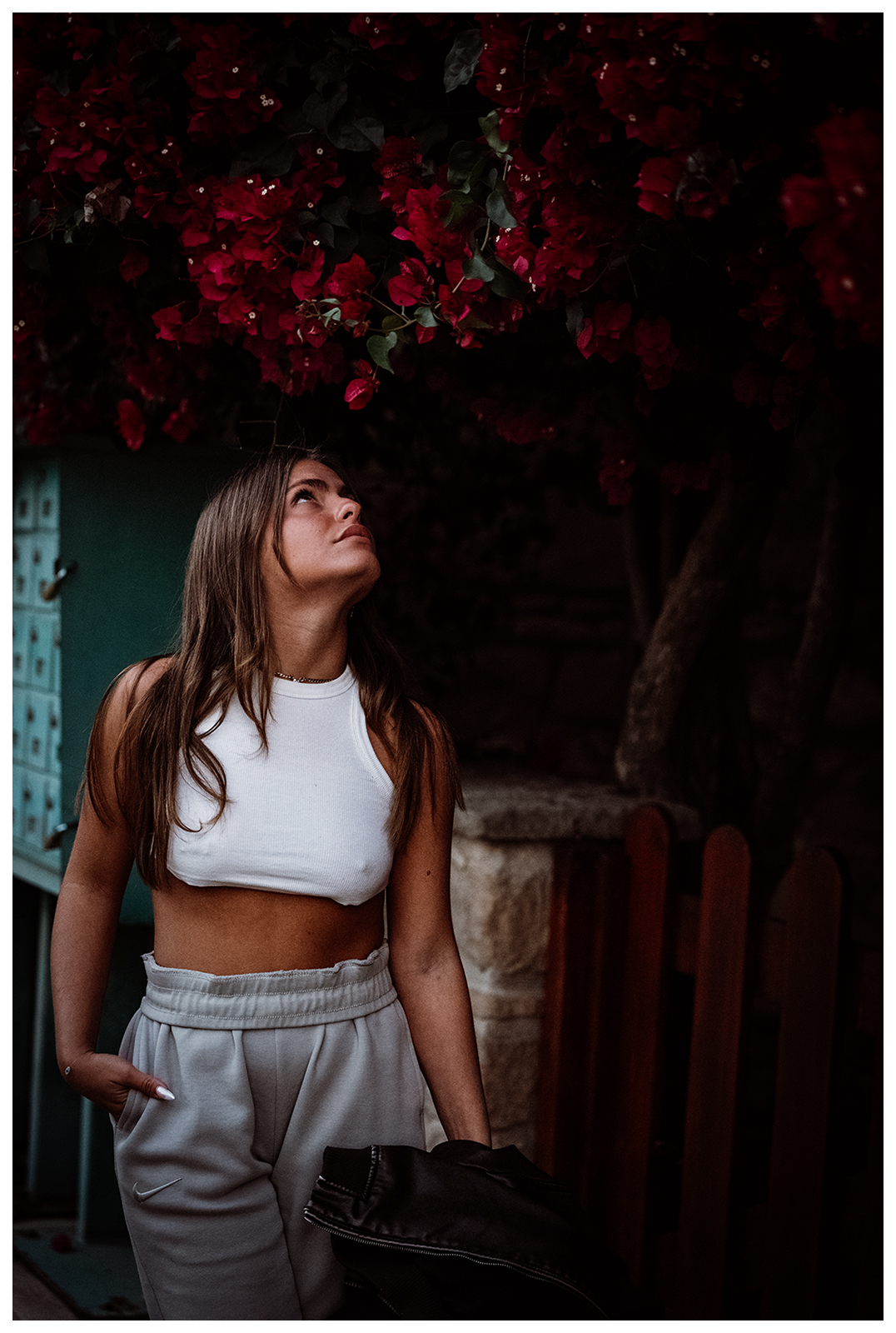 Miliou, Cyprus. A young Israeli woman with long hair stands in front of a blossoming tree.
